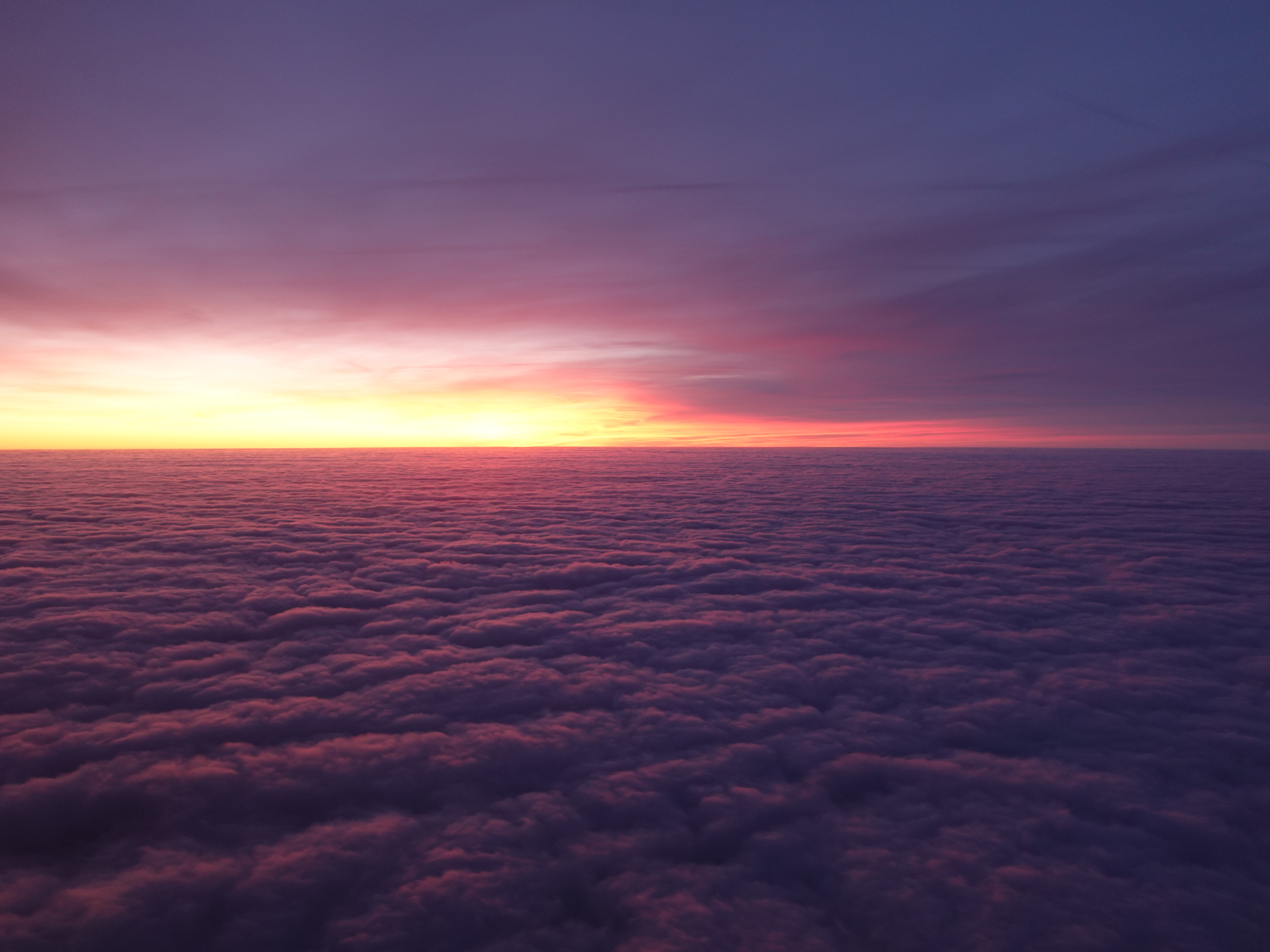 Aerial view of clouds at dusk with sunset on the horizon HD Wallpaper