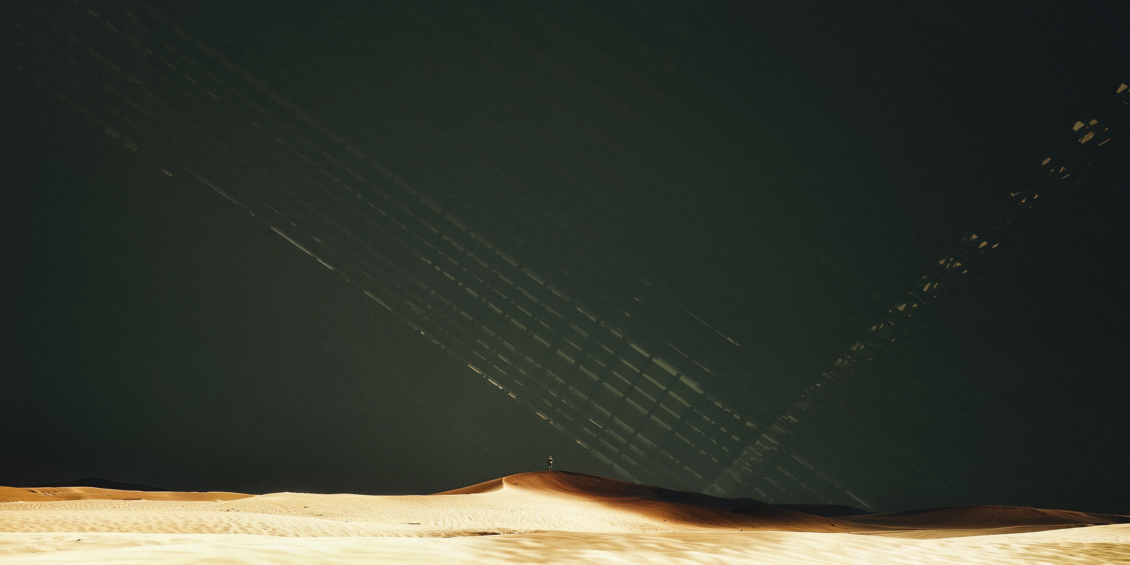 Man standing on a sand dune under abstract light patterns HD Wallpaper