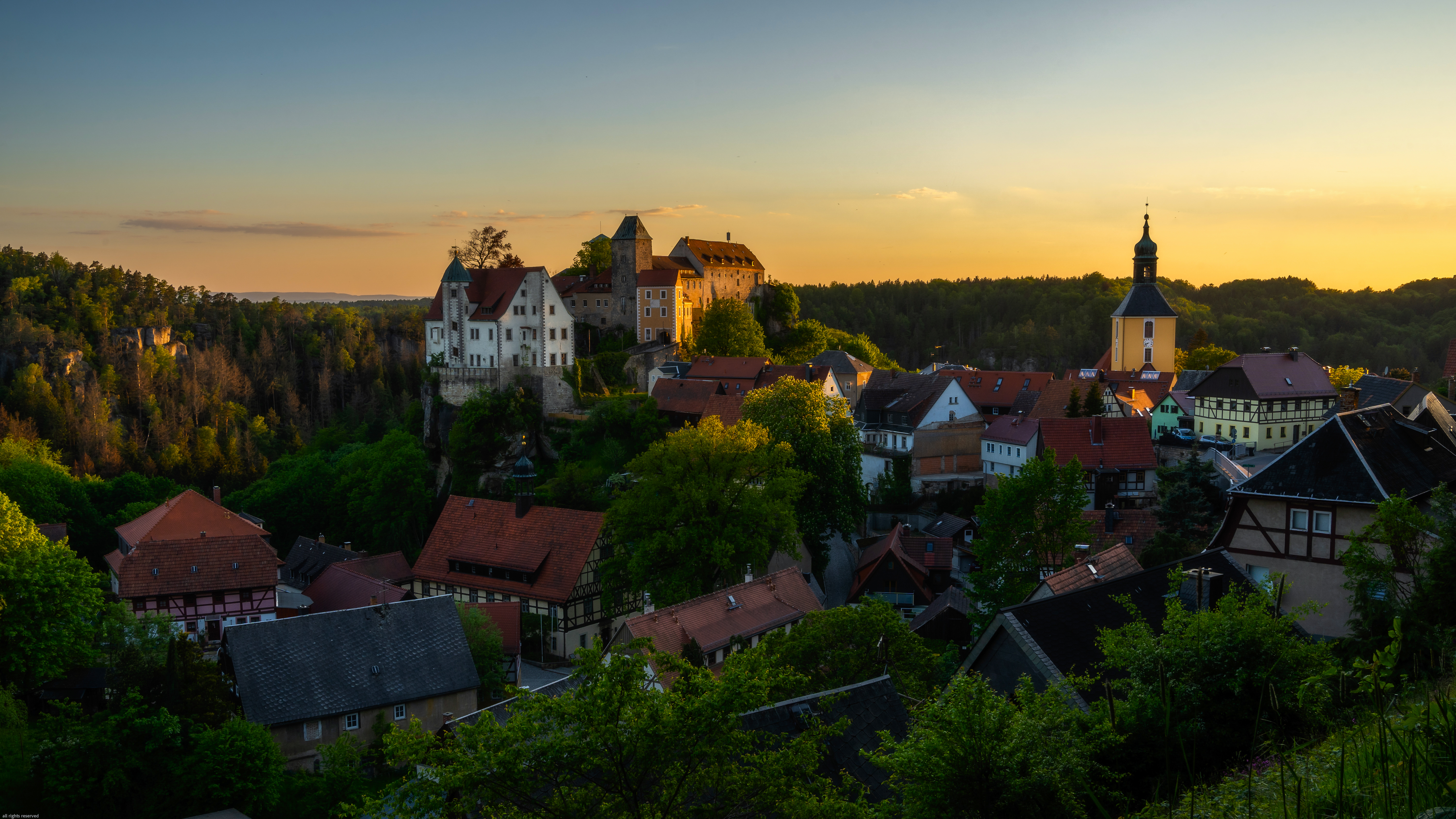 Village and castle at sunset with trees and forest HD Wallpaper