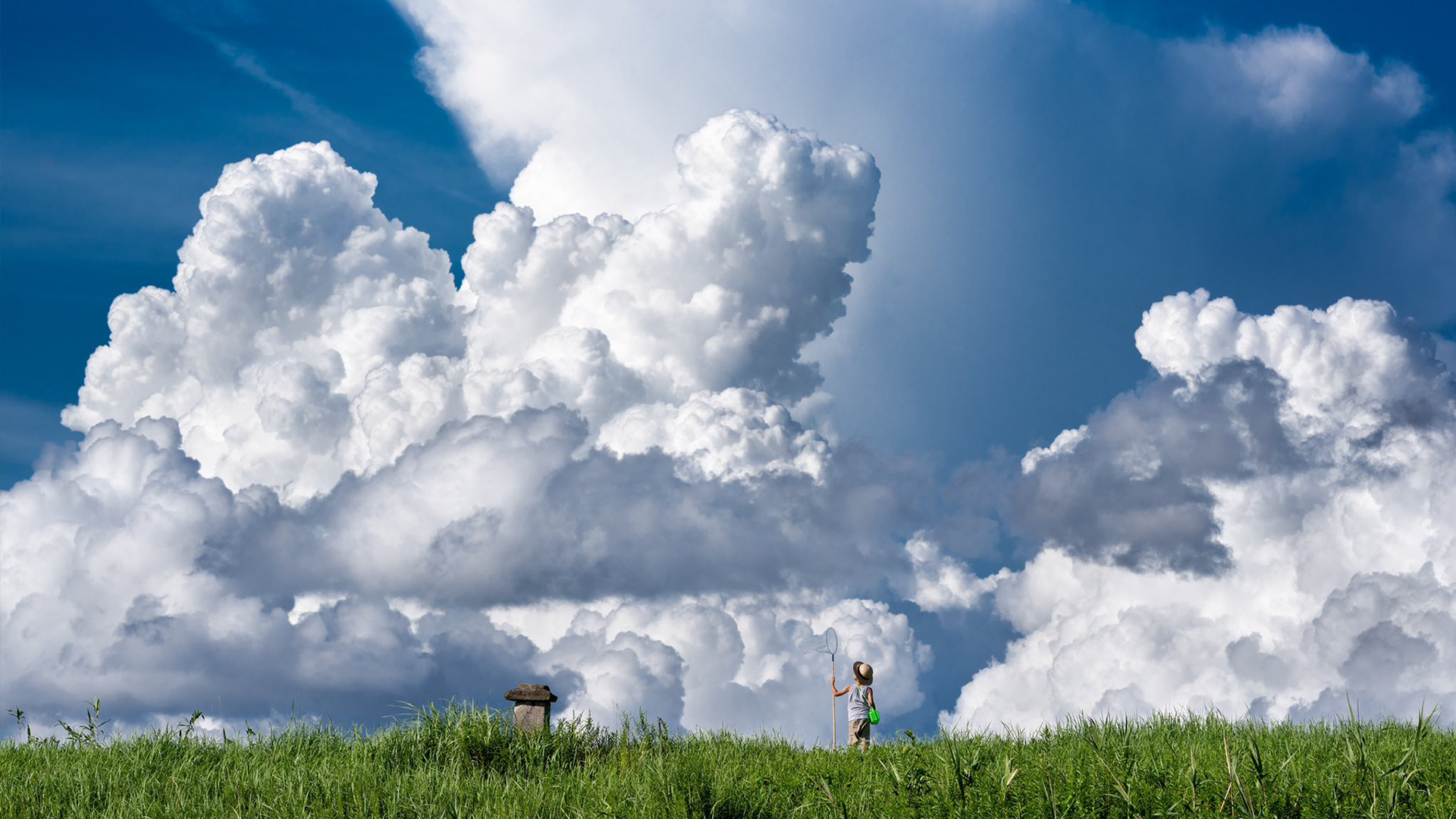 Girl in straw hat looking up at dramatic clouds HD Wallpaper
