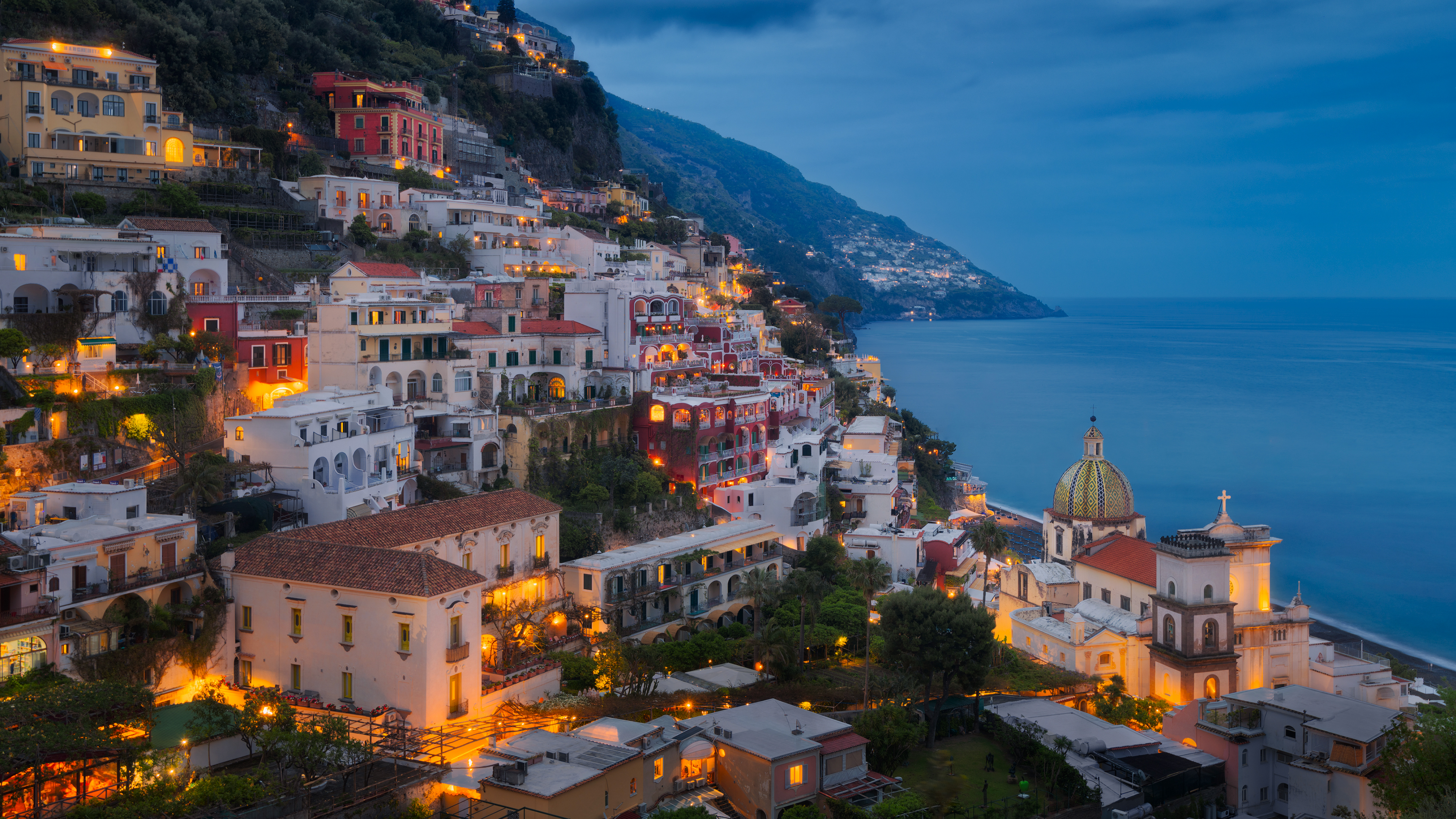 Positano village lights up at dusk by the sea HD Wallpaper