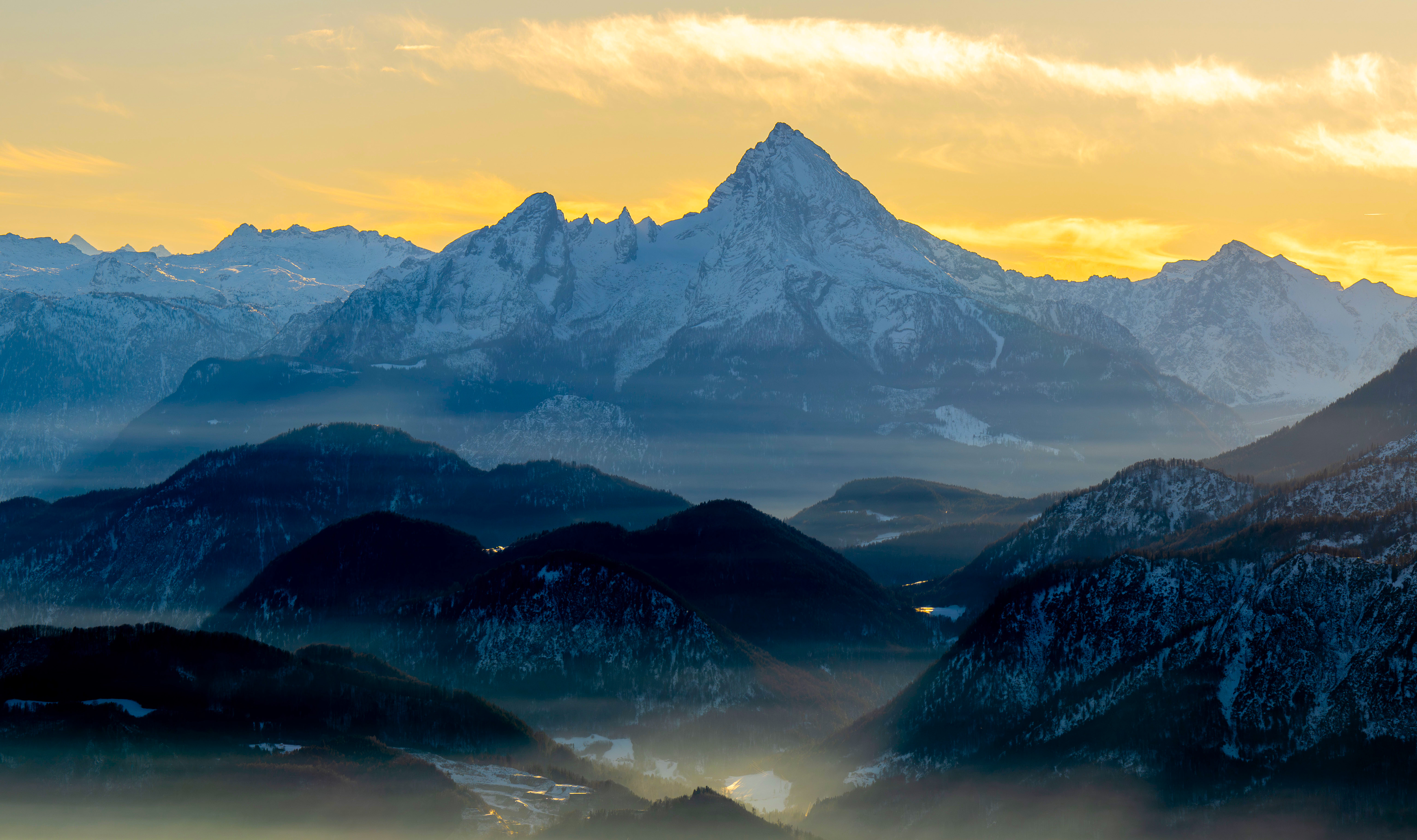 Snow-capped mountains shrouded in mist at sunrise HD Wallpaper