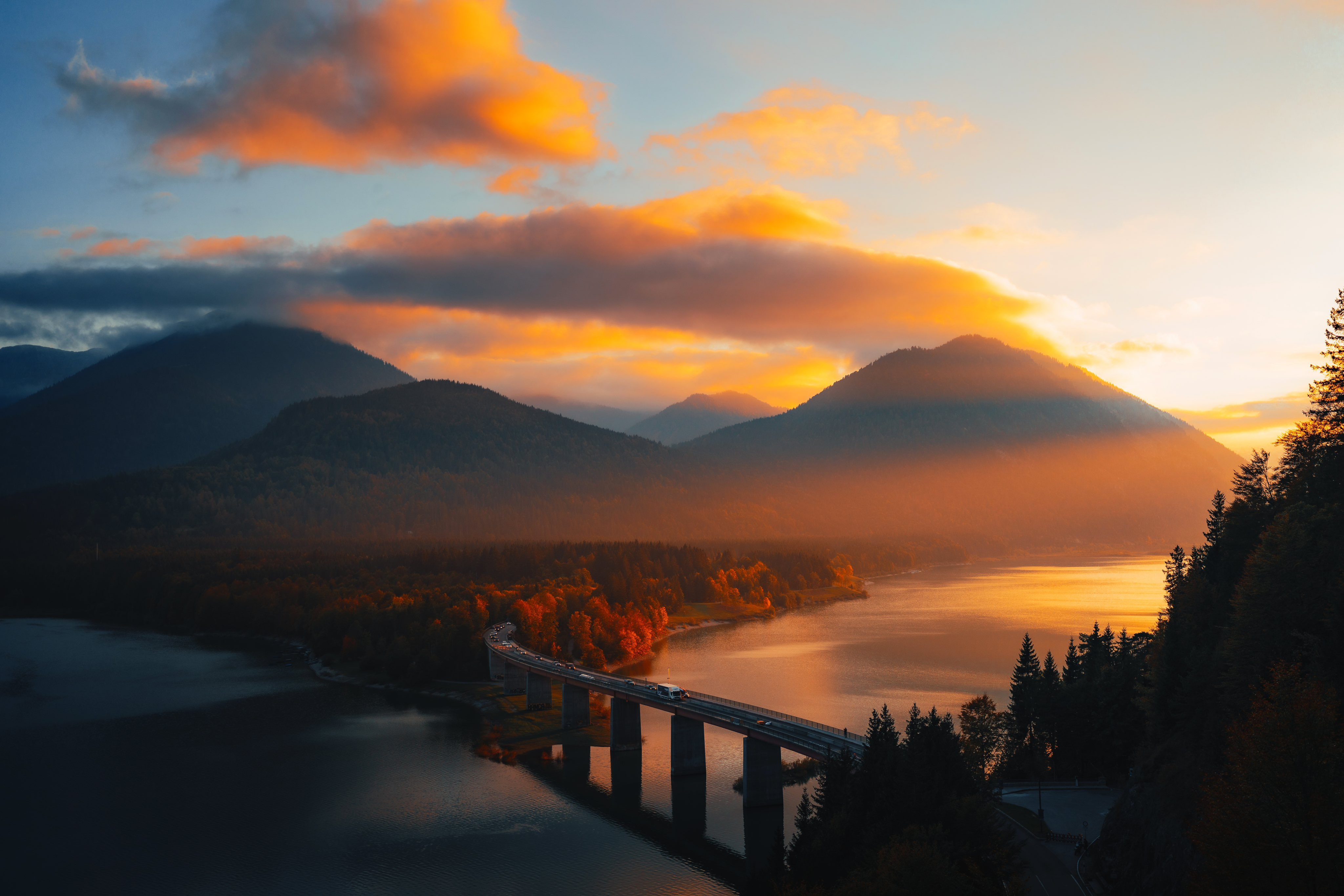 Bridge over a lake with mountains at sunset HD Wallpaper