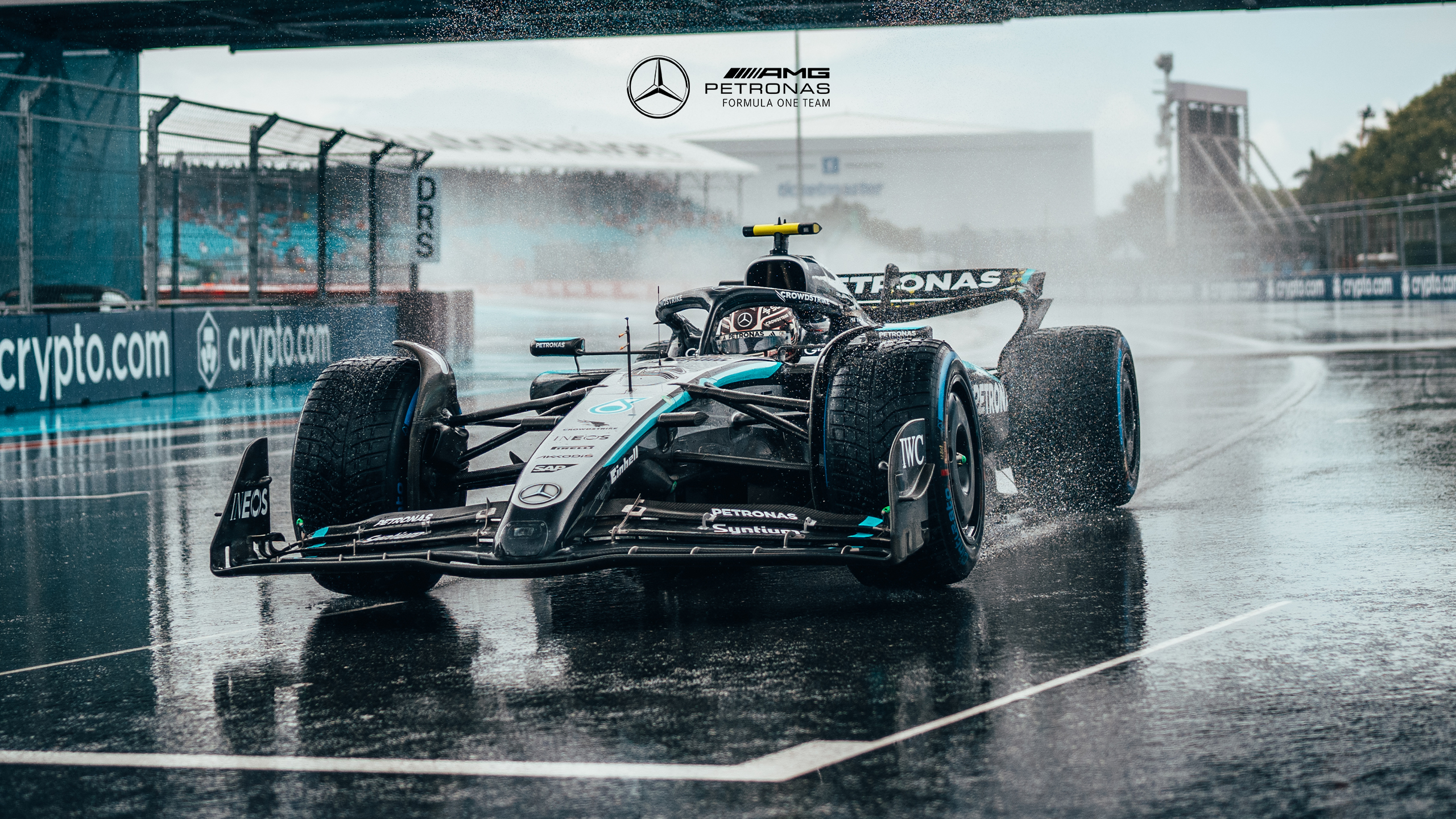 Mercedes AMG Petronas Formula 1 car on wet race track HD Wallpaper