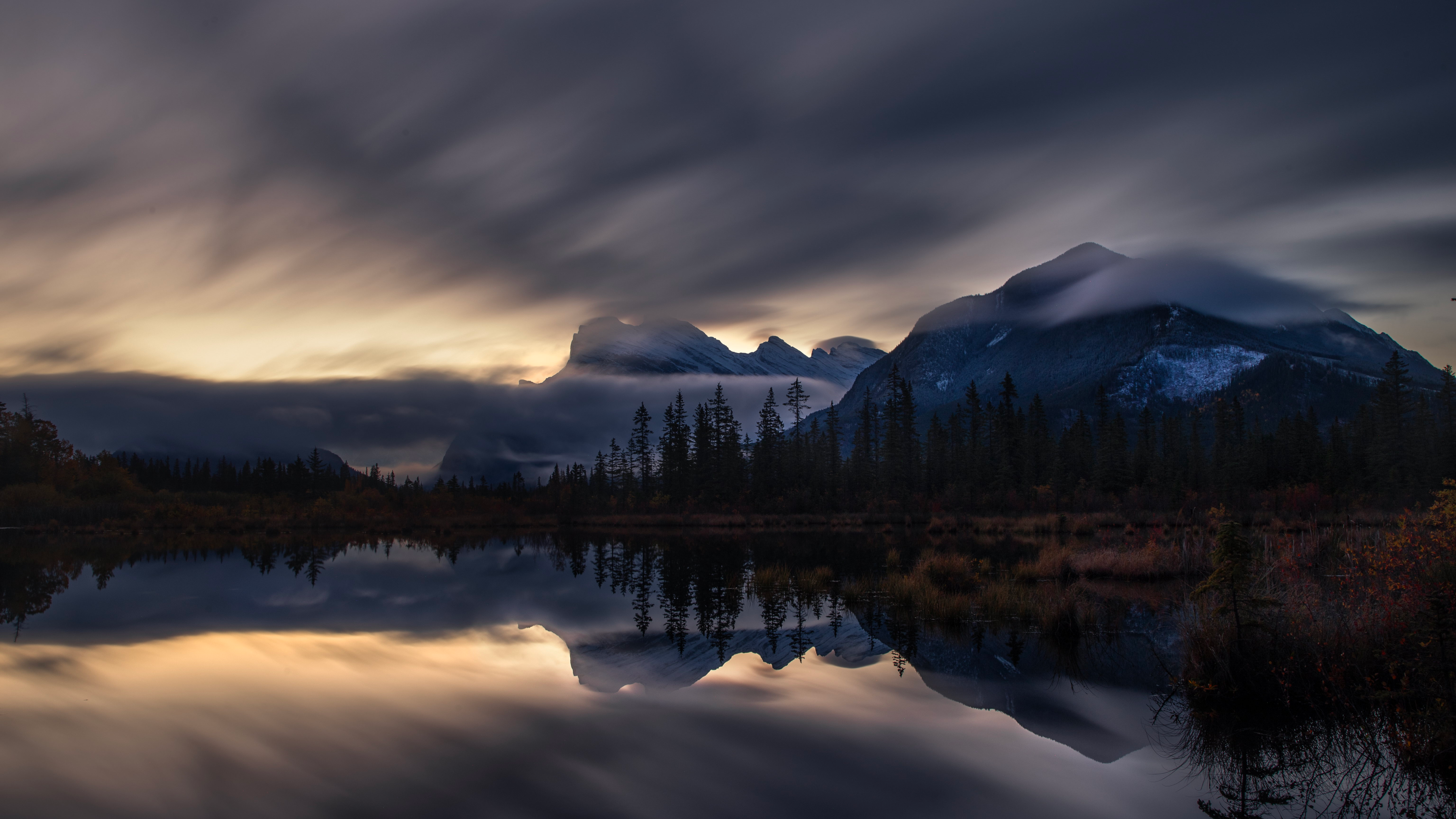 Mountains reflected in a lake under cloudy sky HD Wallpaper