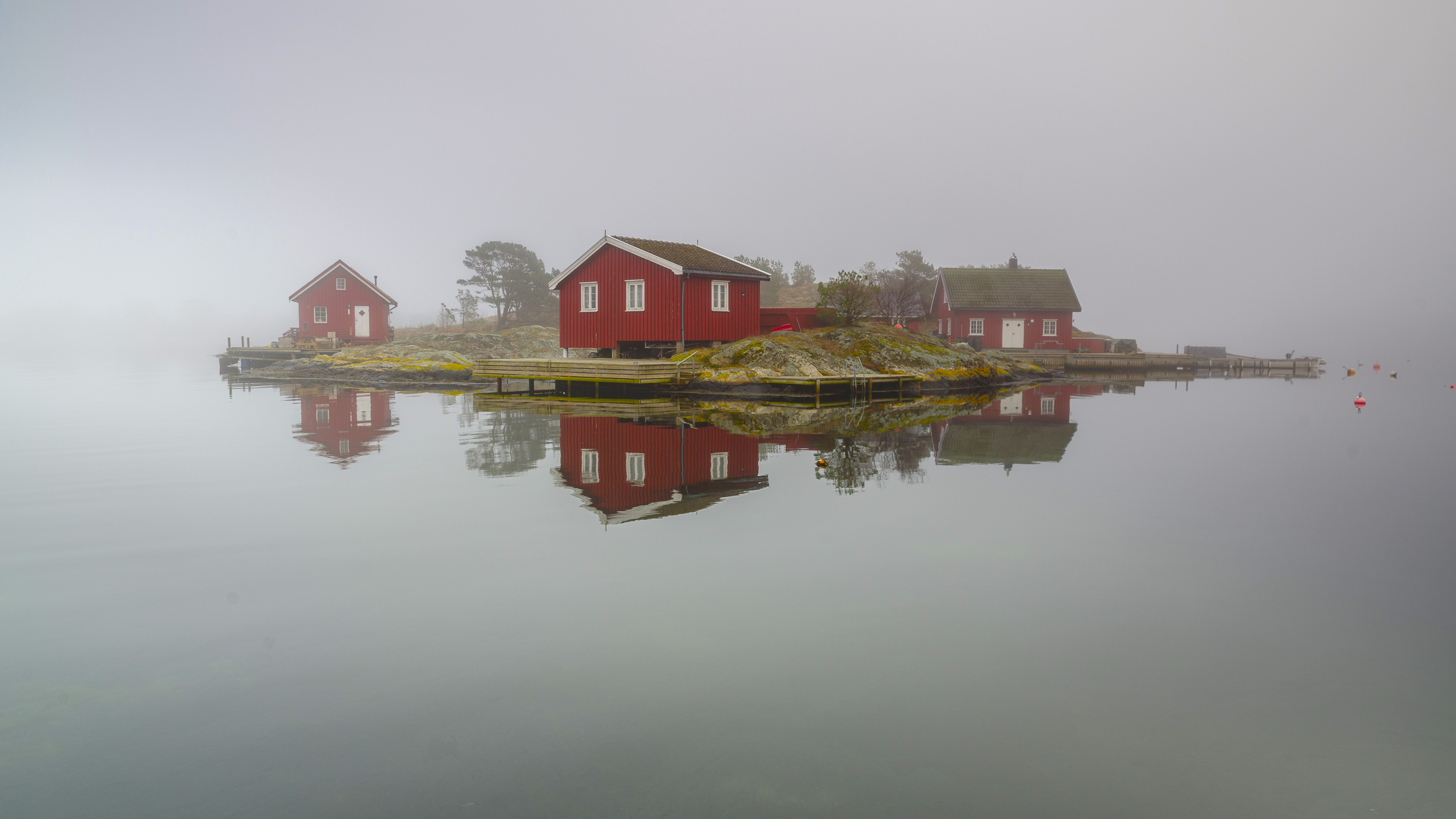 Red houses on a misty island with water reflection HD Wallpaper
