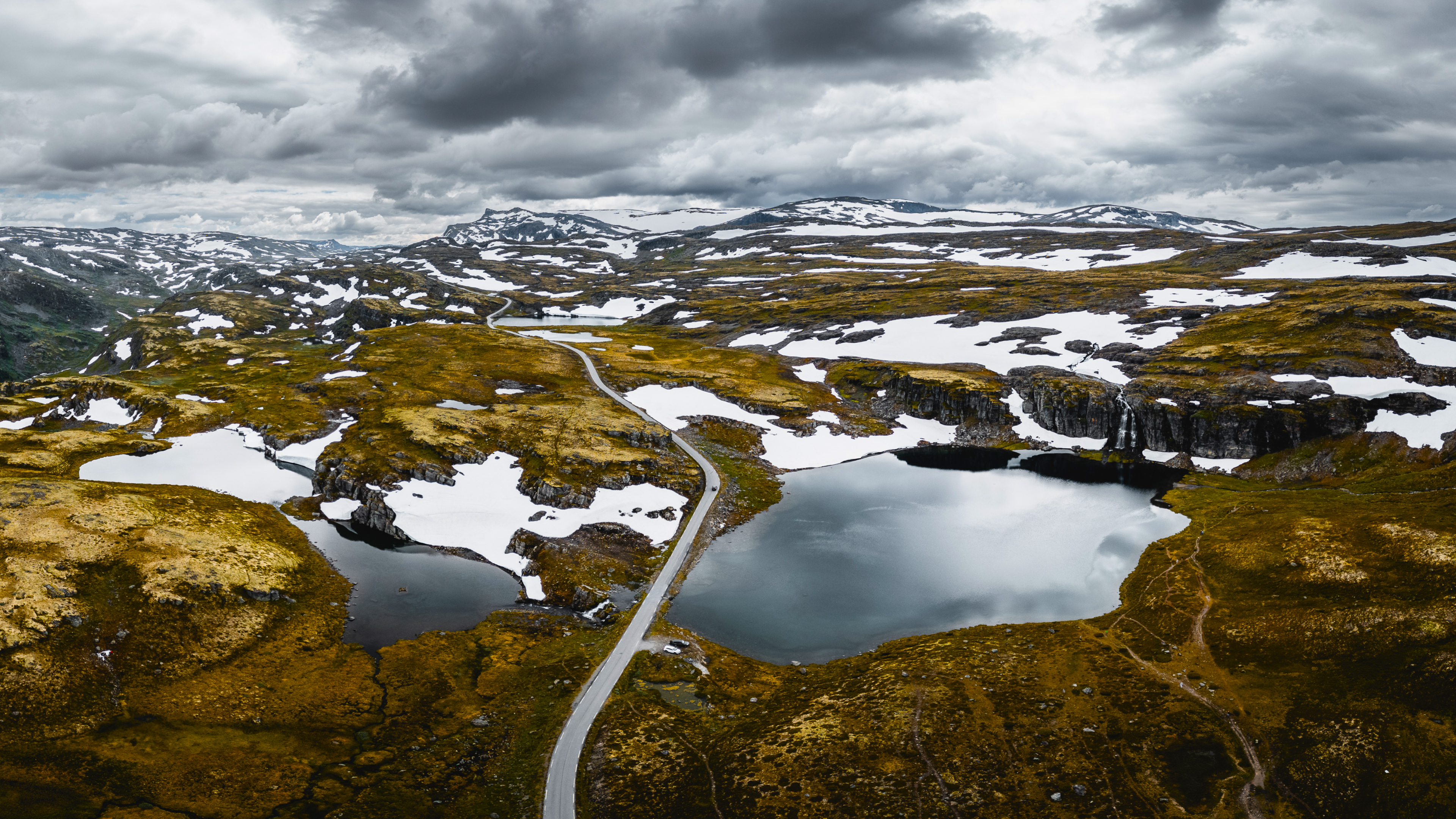Mountain landscape with lakes and snow patches HD Wallpaper