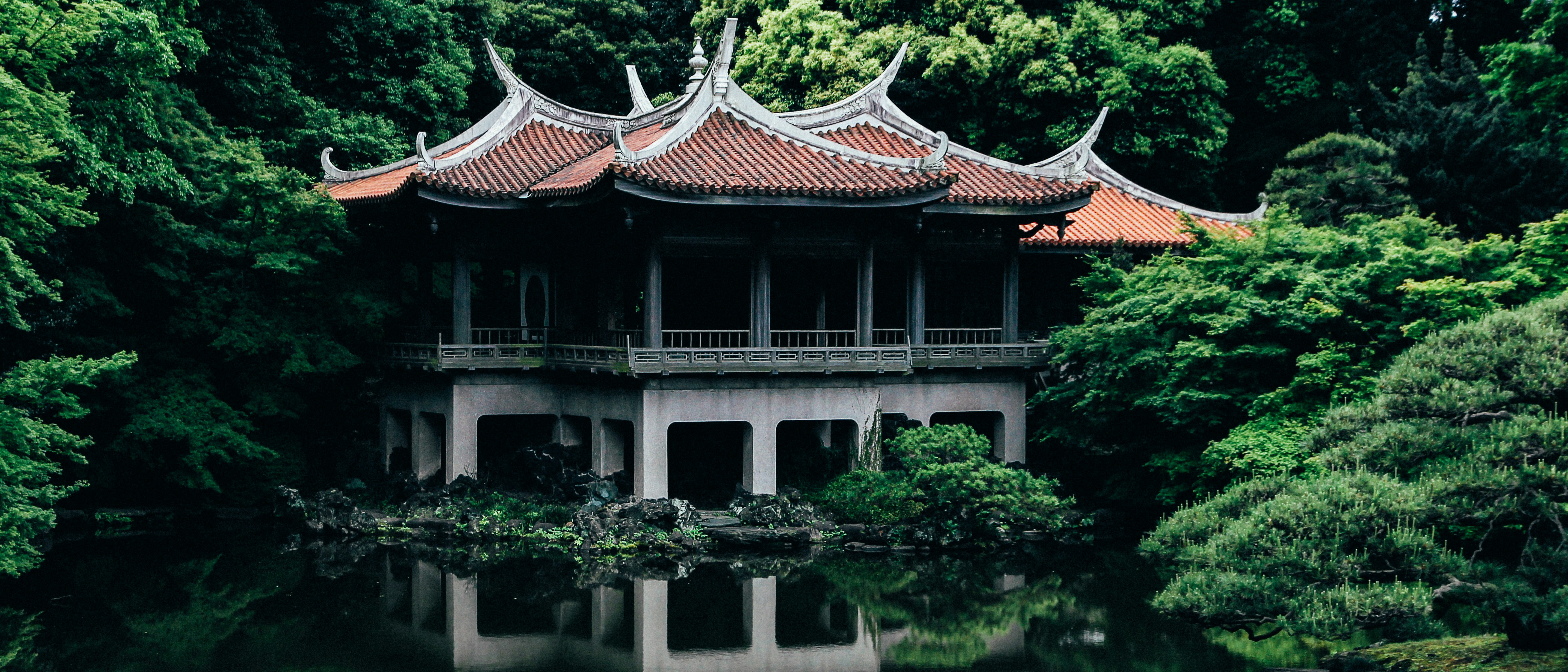 Asian architecture building reflected in water surrounded by trees HD Wallpaper