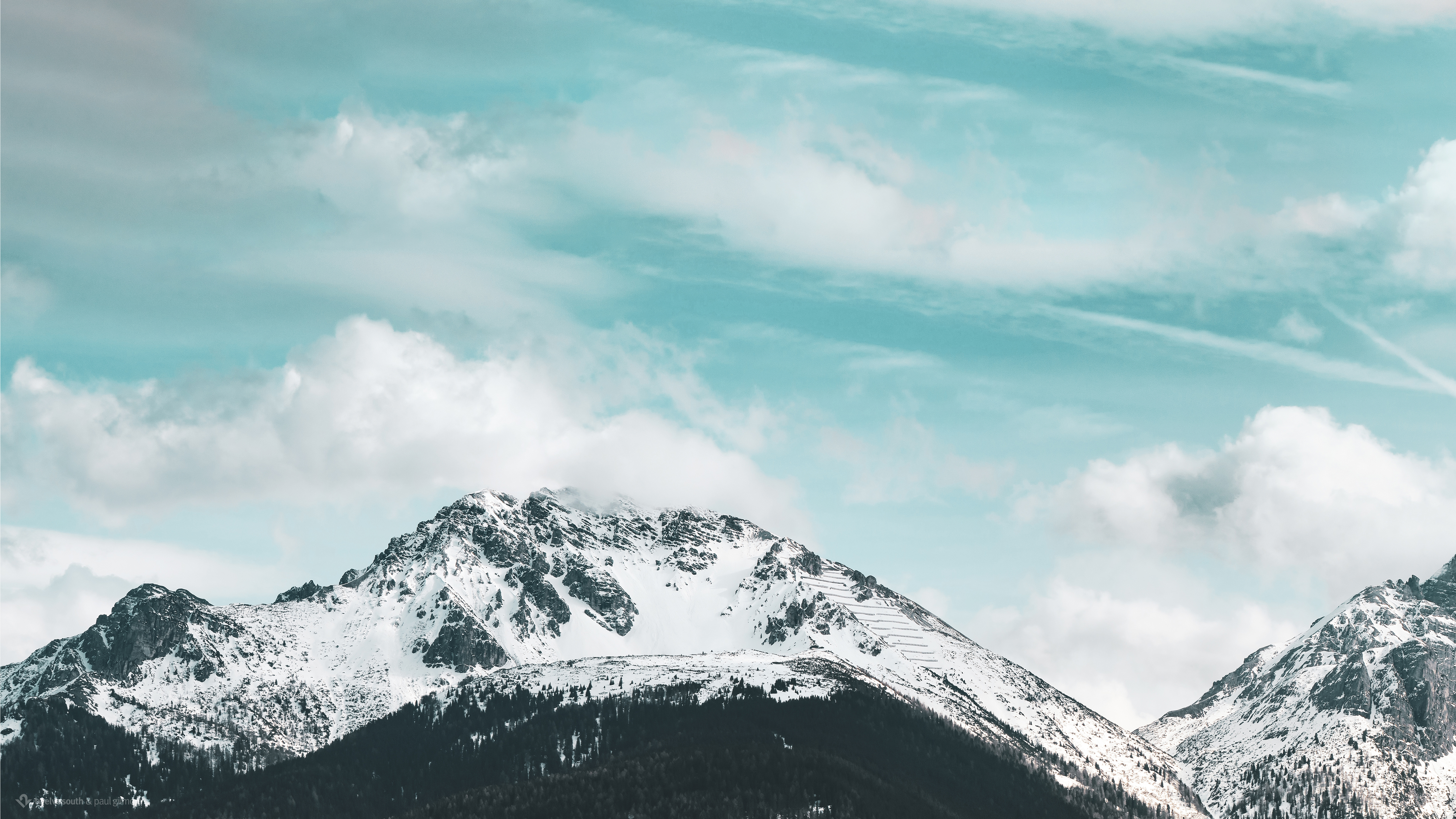 Snow covered mountains under a cloudy sky HD Wallpaper