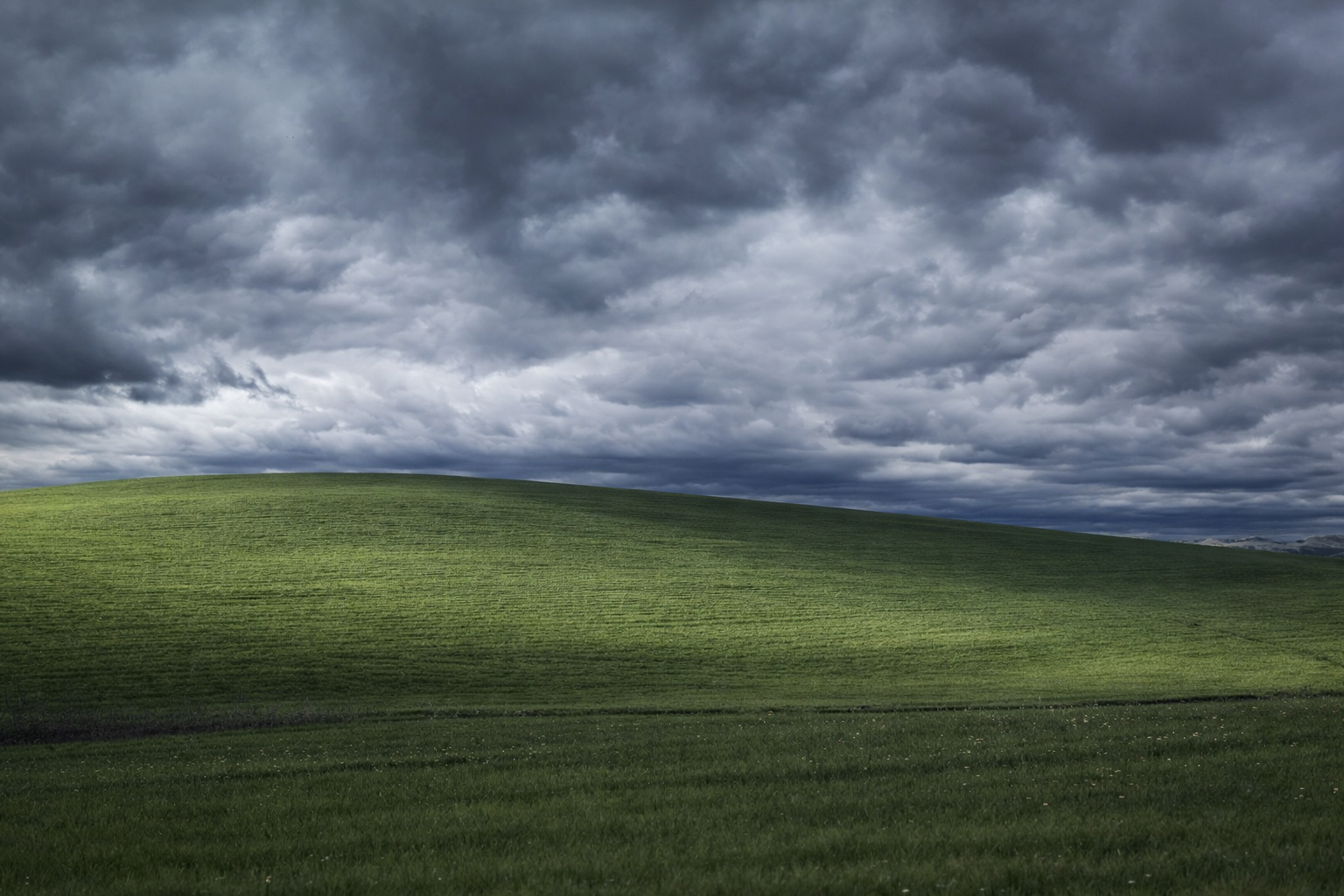 Green rolling hills under a cloudy sky HD Wallpaper