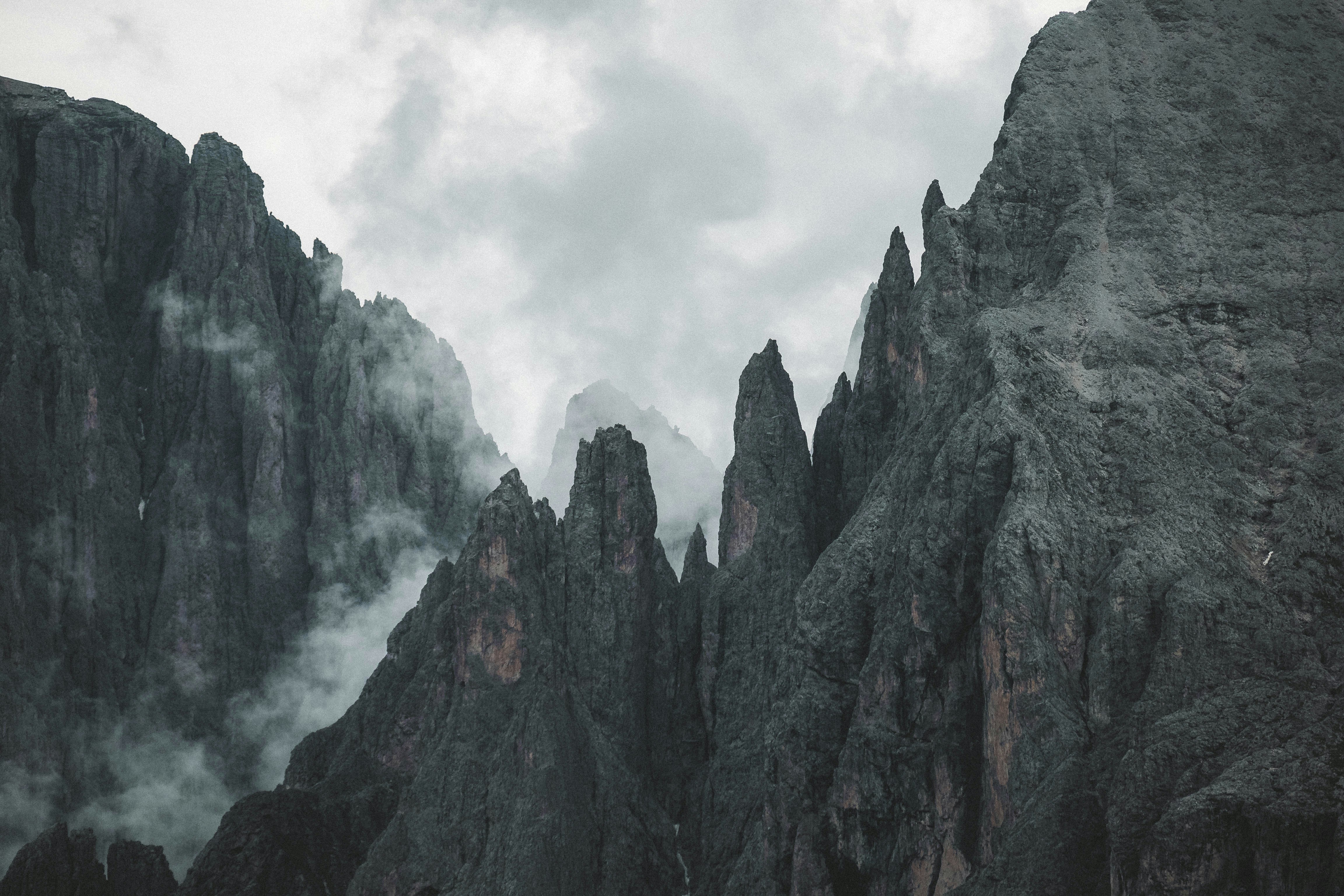 Jagged mountain peaks shrouded in mist HD Wallpaper