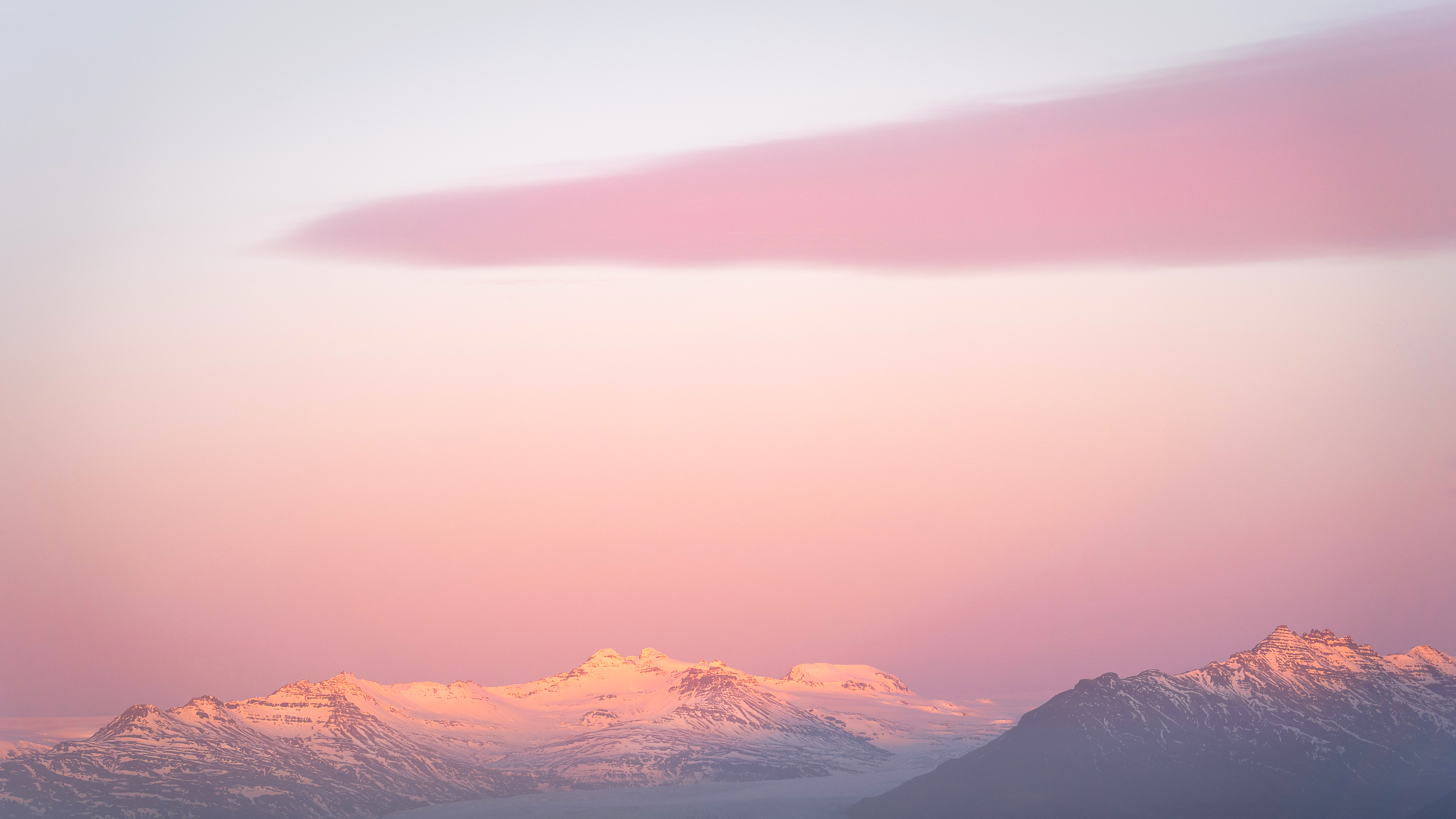 Snow-capped mountains under a pink sunrise cloud HD Wallpaper