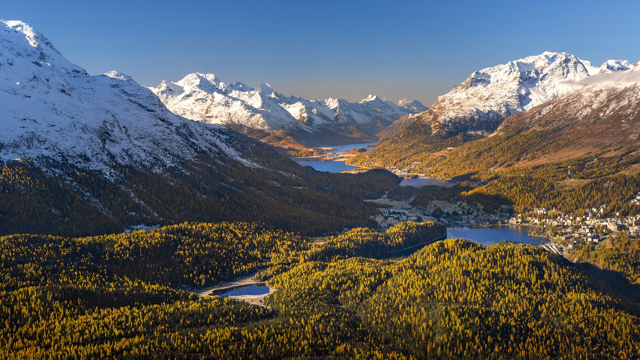 Snow-capped mountains and golden forest surround lakes HD Wallpaper