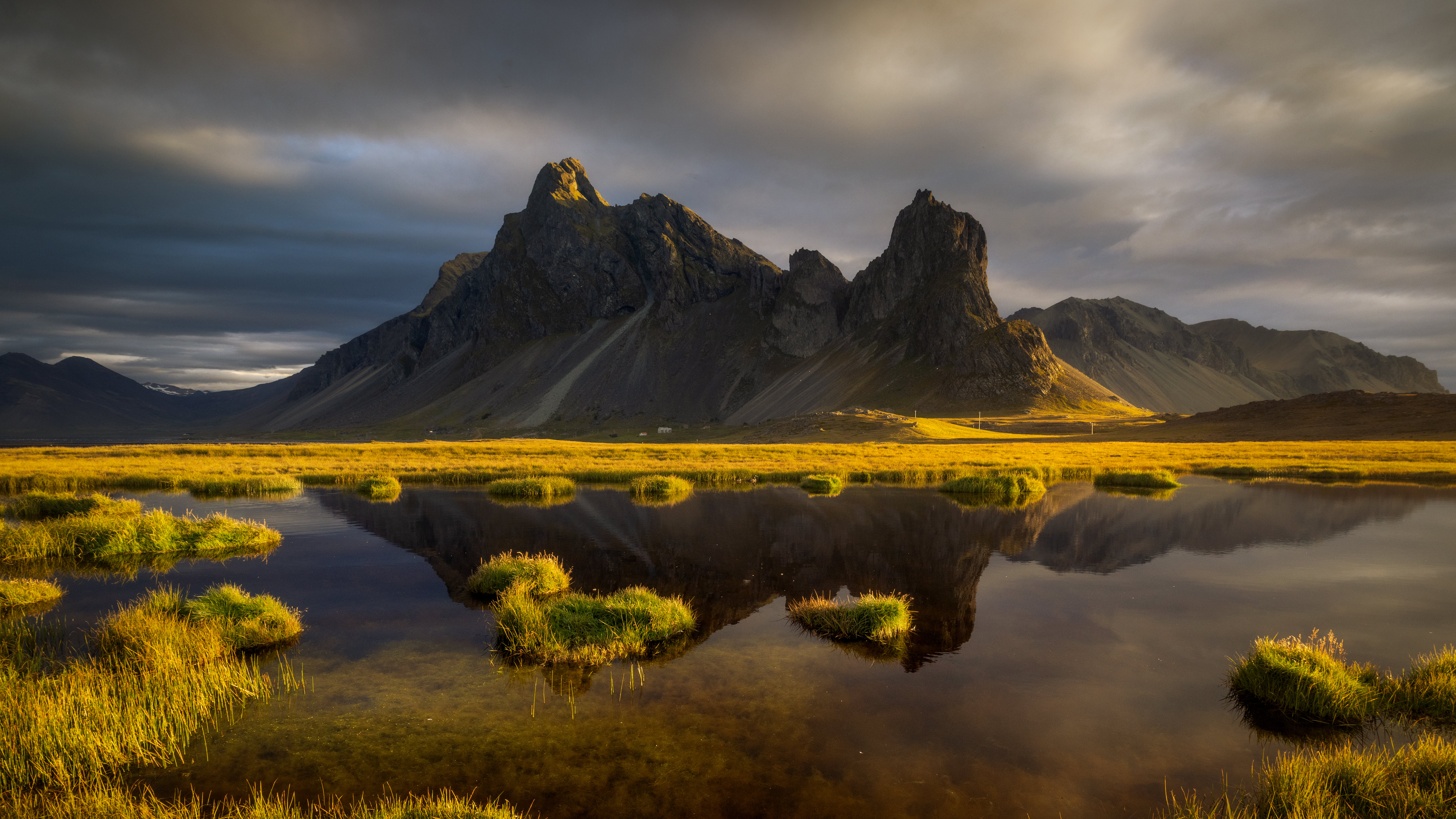 Mountain reflection in water with grass and clouds HD Wallpaper