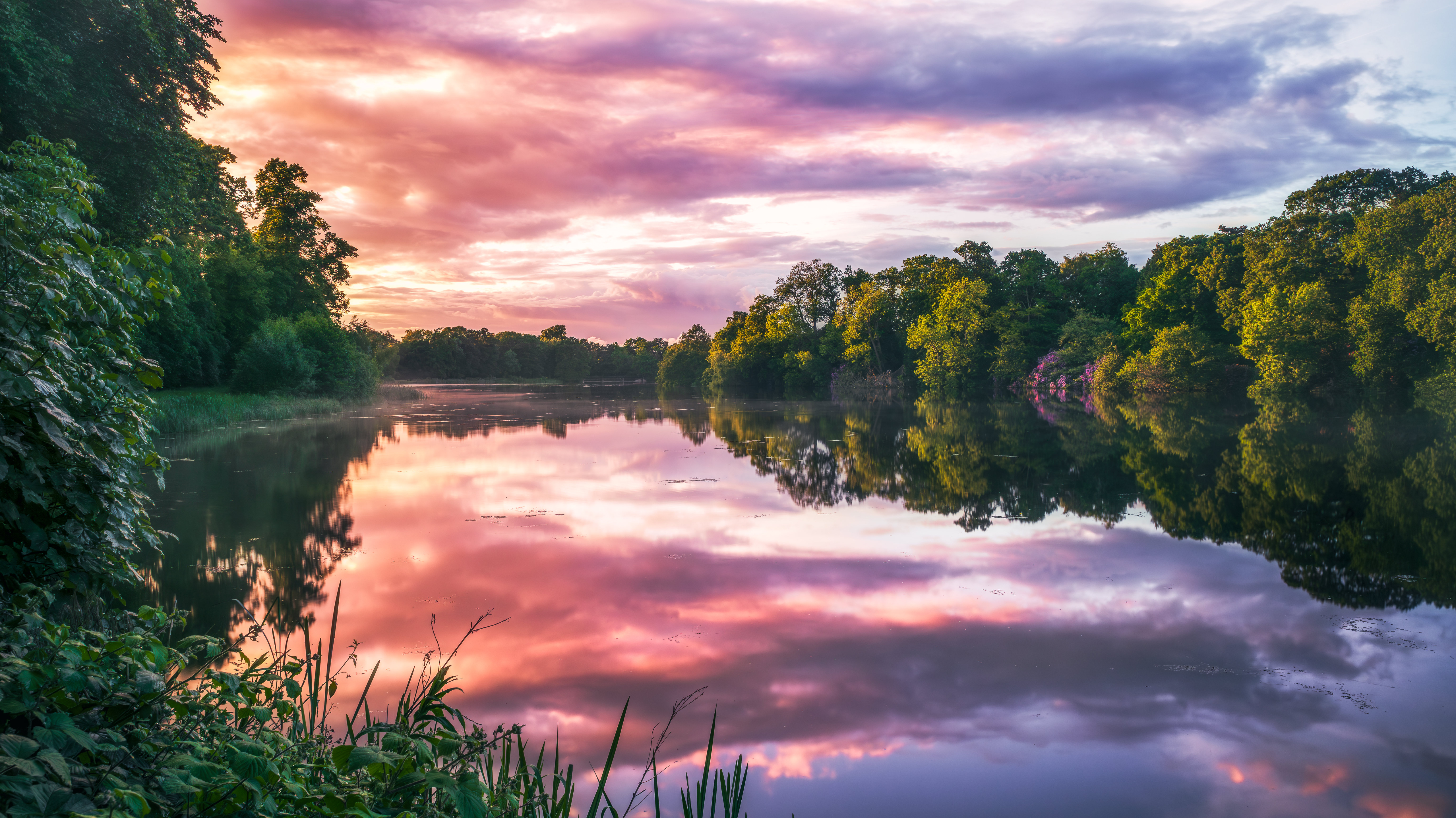 Sunset over a calm river with trees and clouds HD Wallpaper