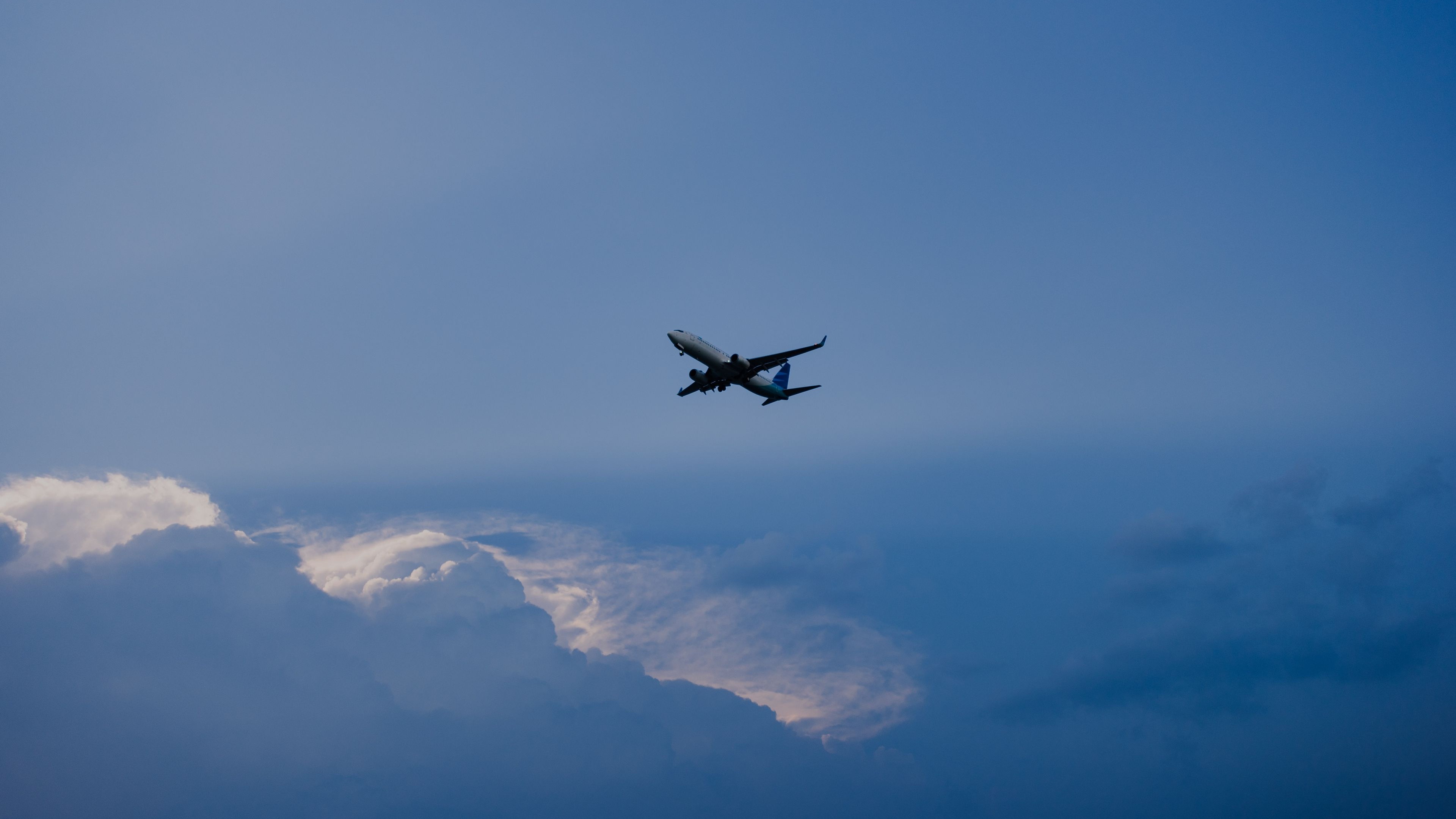 Airplane flying in a blue sky with clouds HD Wallpaper