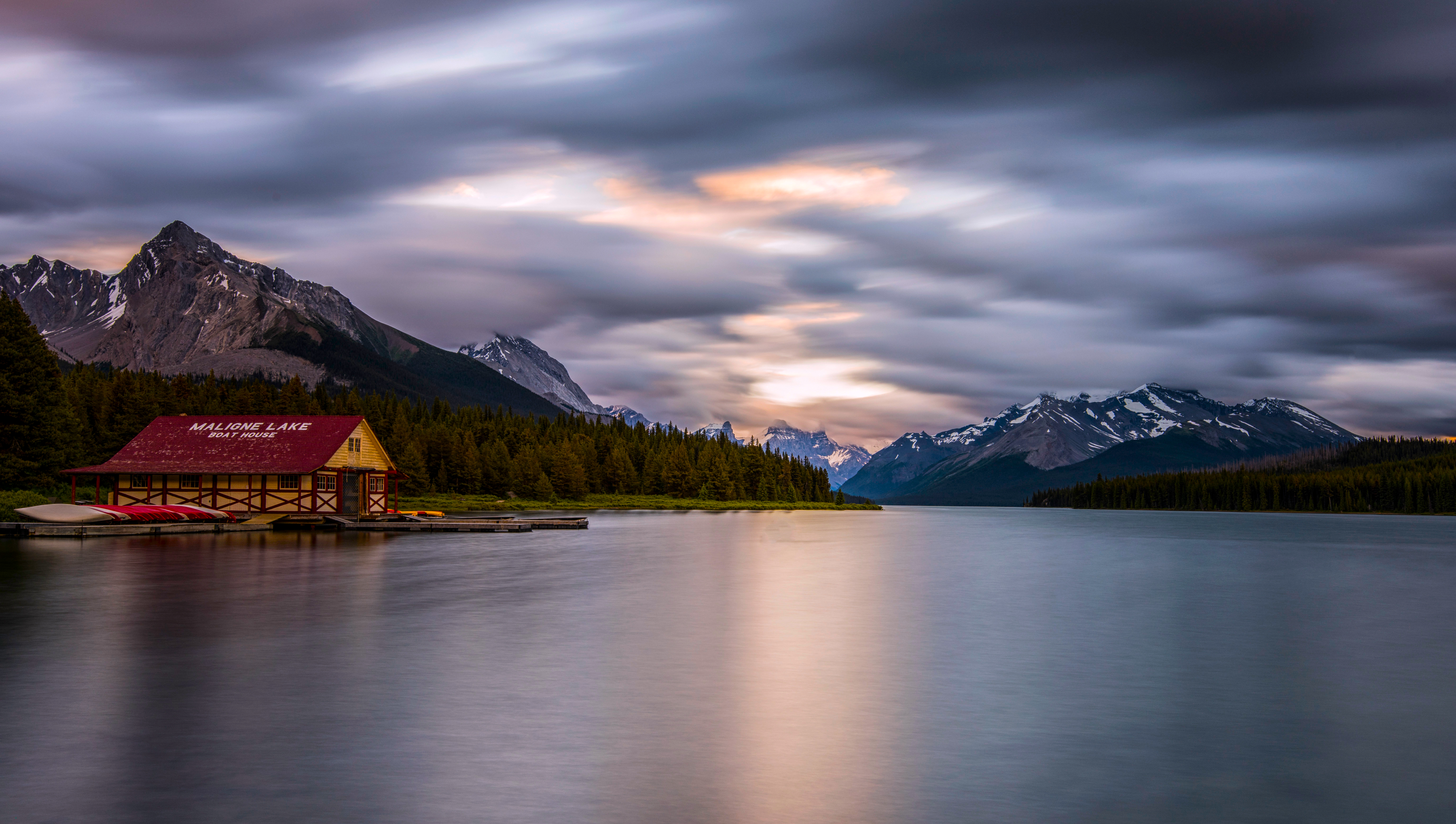 Boat house on Maligne Lake with mountains and clouds HD Wallpaper