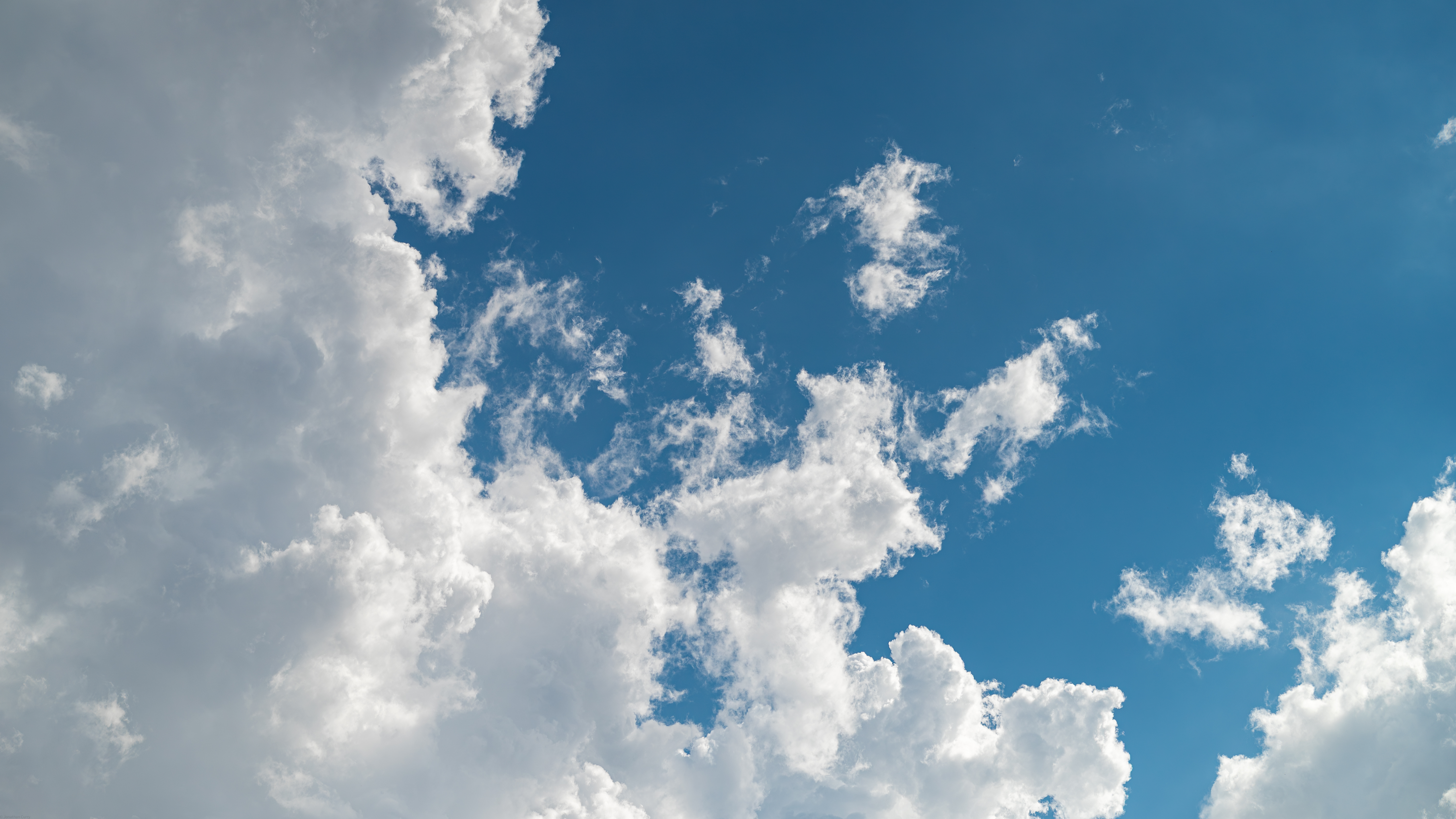 White clouds against a bright blue sky HD Wallpaper