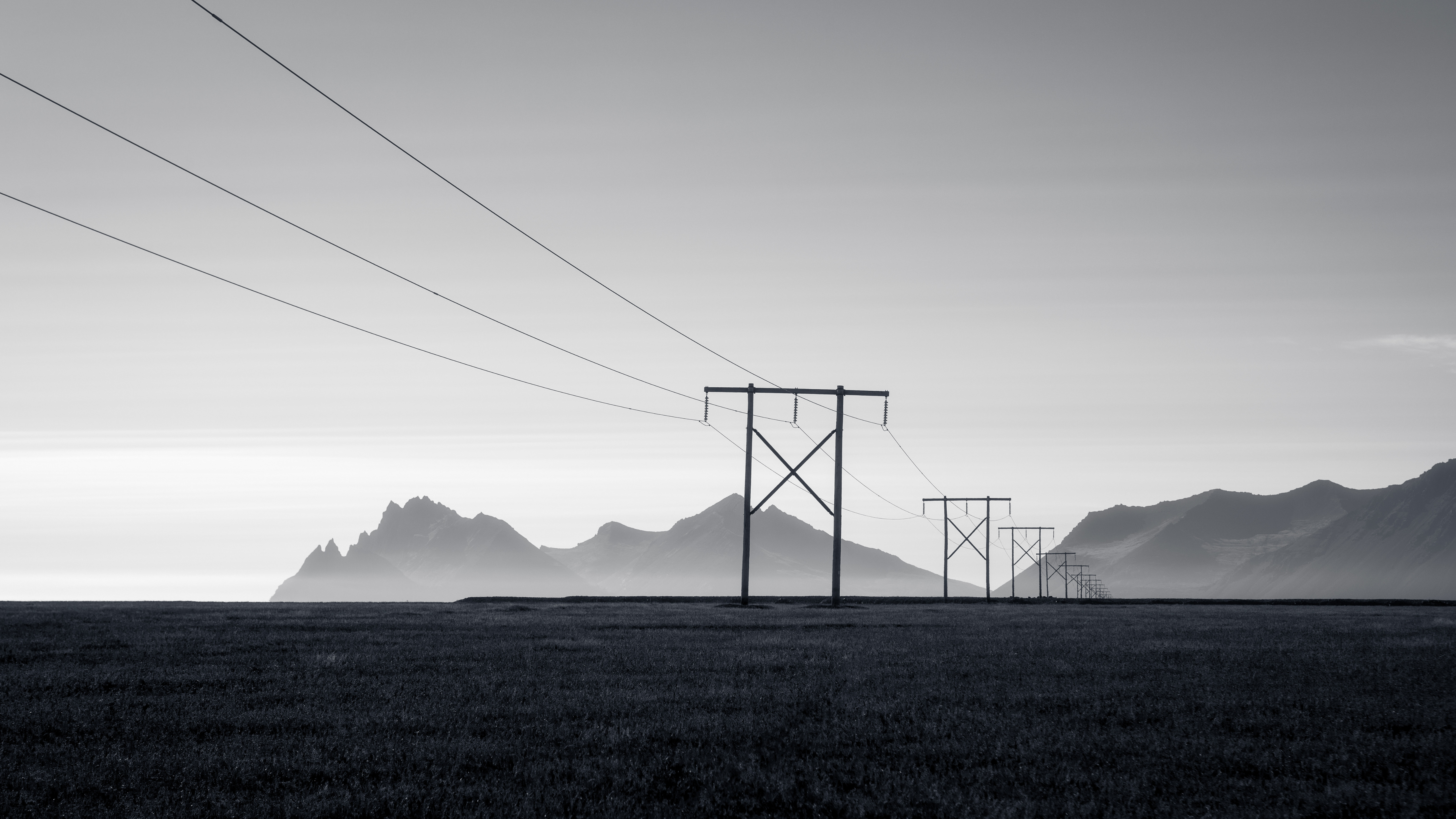 Monochrome landscape with pylons and mountains HD Wallpaper