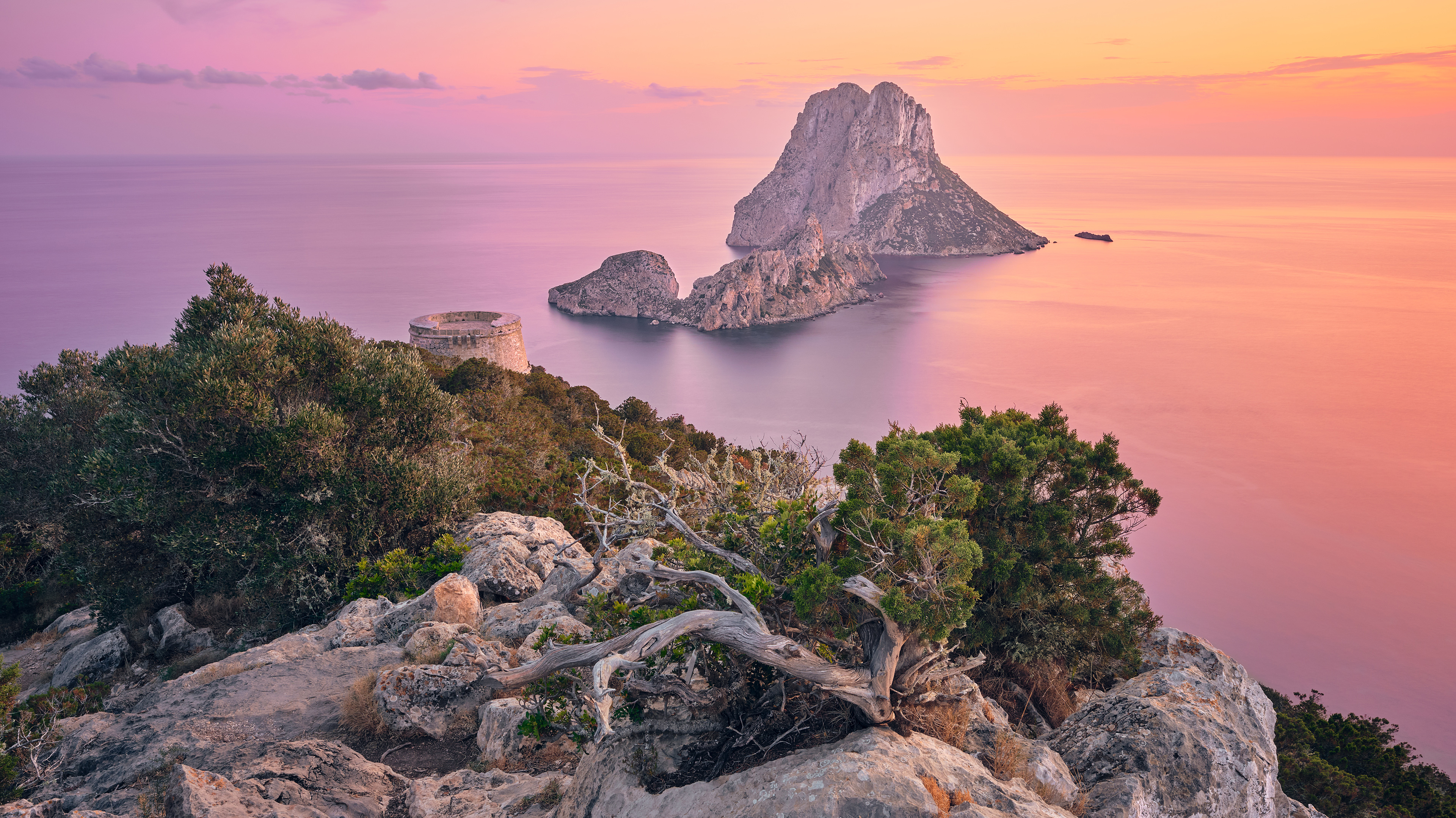 Rocky cliff overlooking Es Vedrà island at sunset HD Wallpaper