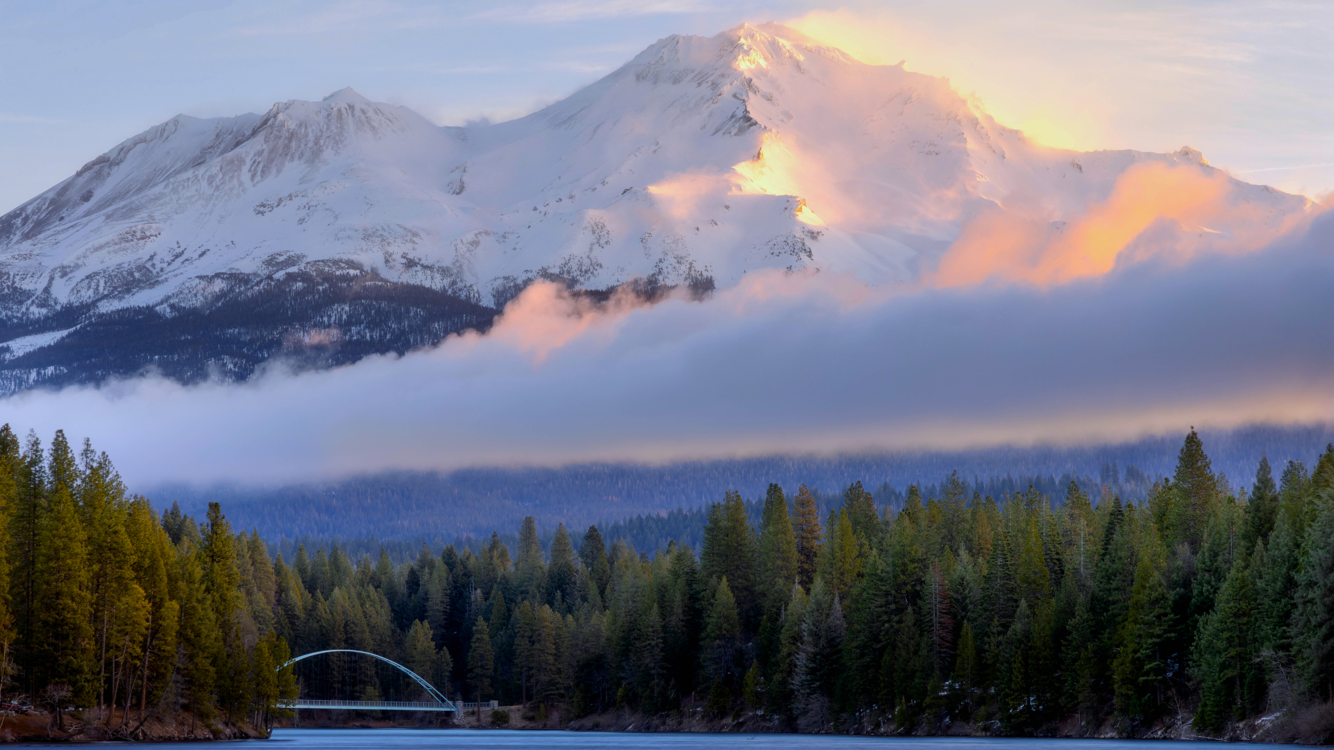Snow-capped mountain peak with clouds and forest HD Wallpaper