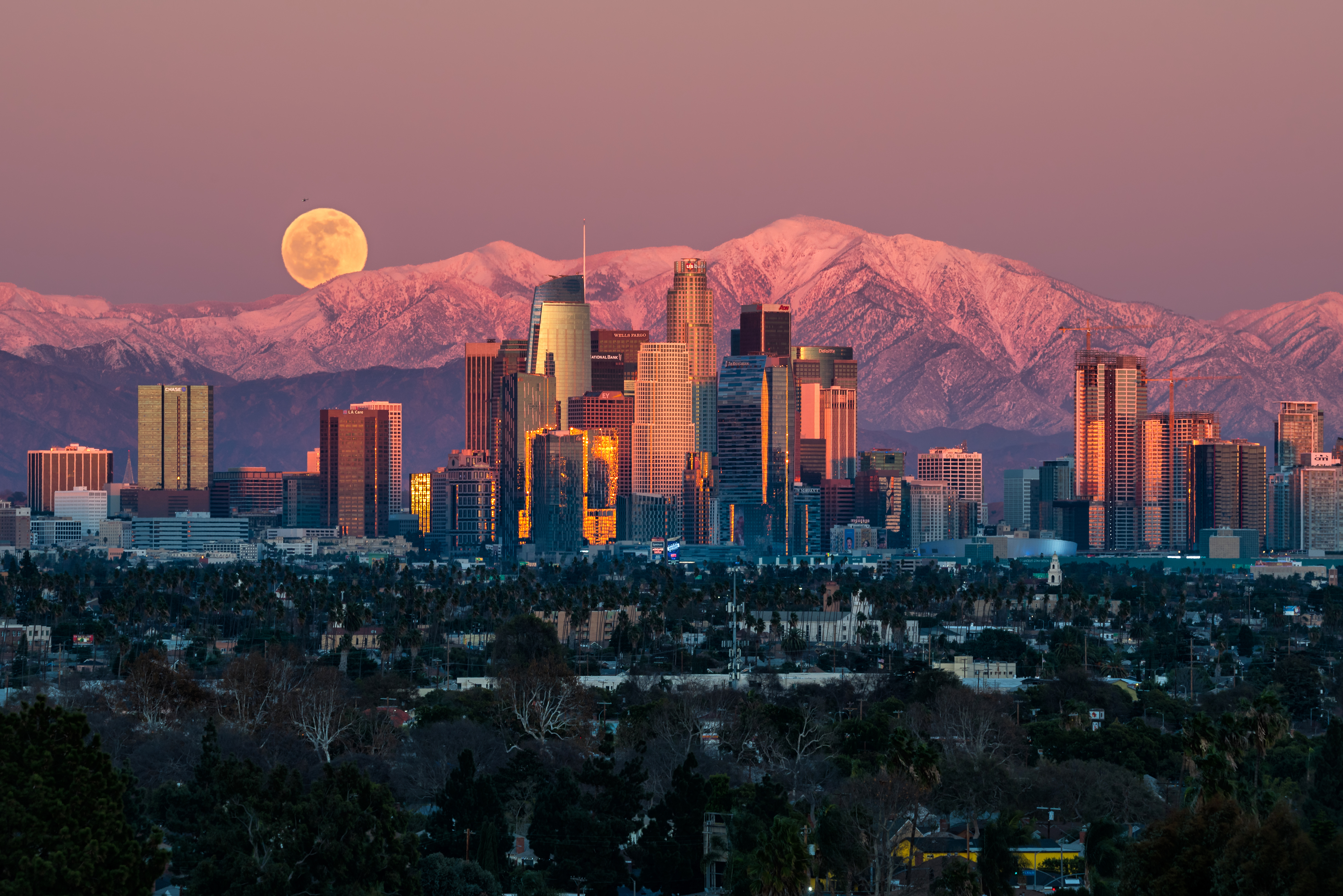 Los Angeles cityscape with moon and snow-capped mountains HD Wallpaper