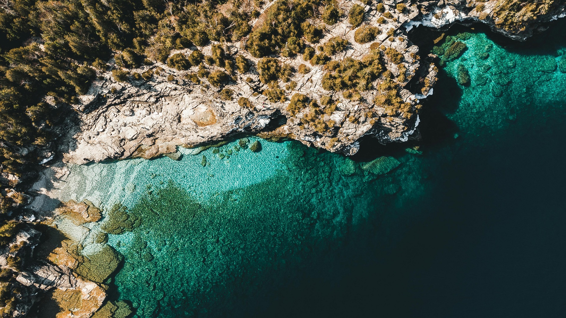Aerial view of rocky coastline and clear turquoise sea HD Wallpaper