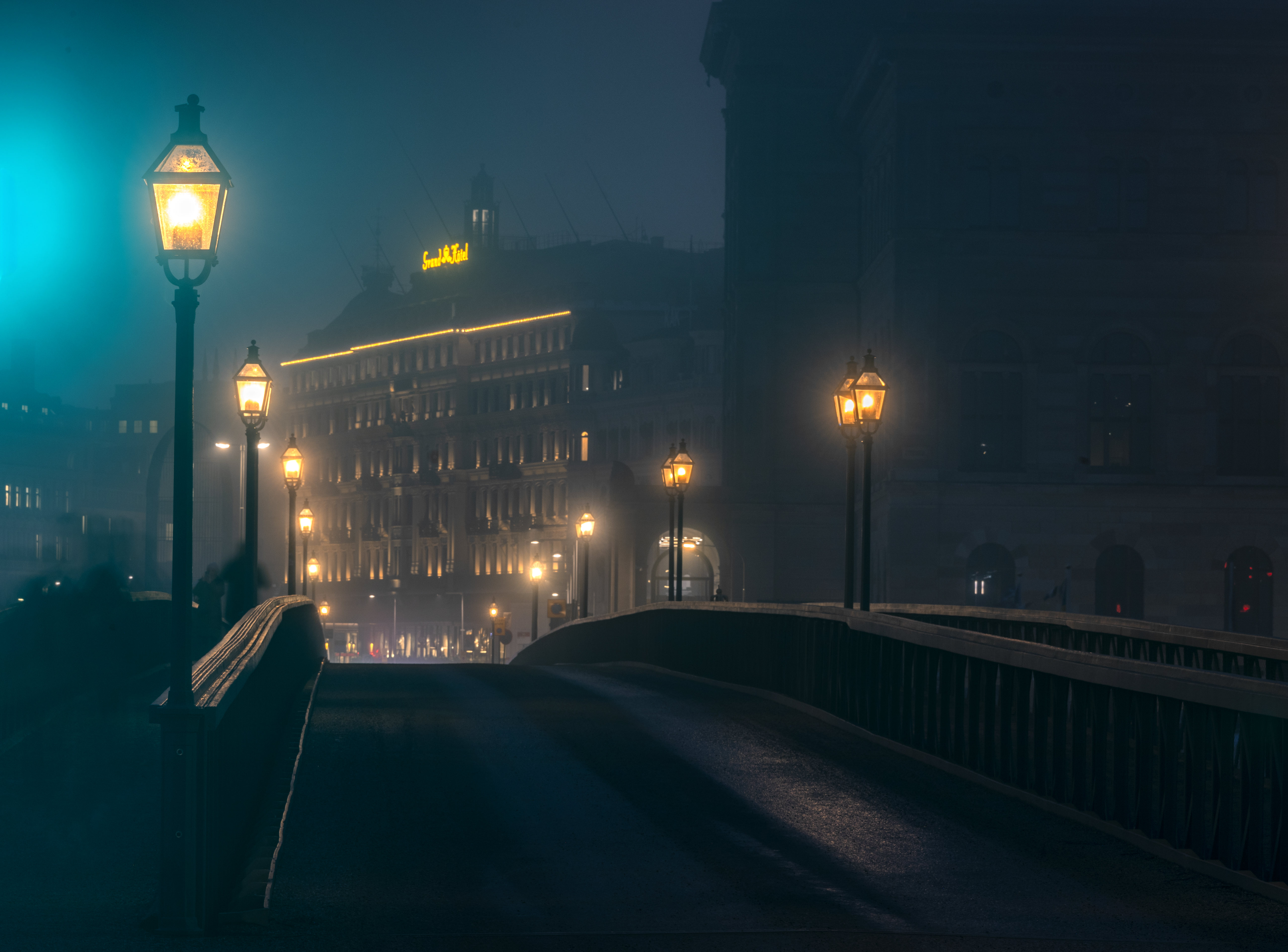 Foggy night over a bridge with street lamps and hotel HD Wallpaper