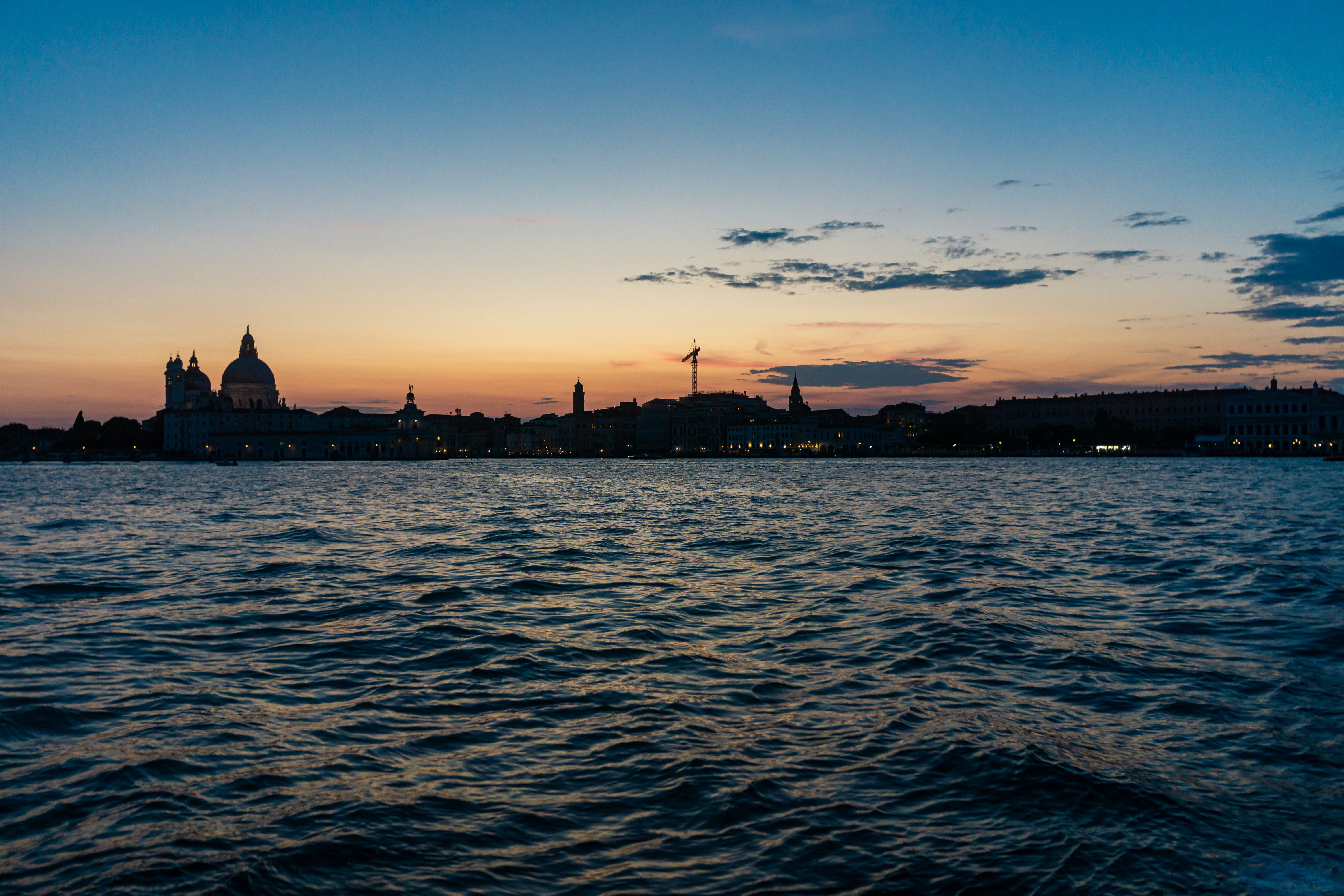 Venice skyline at sunset over rippling water HD Wallpaper