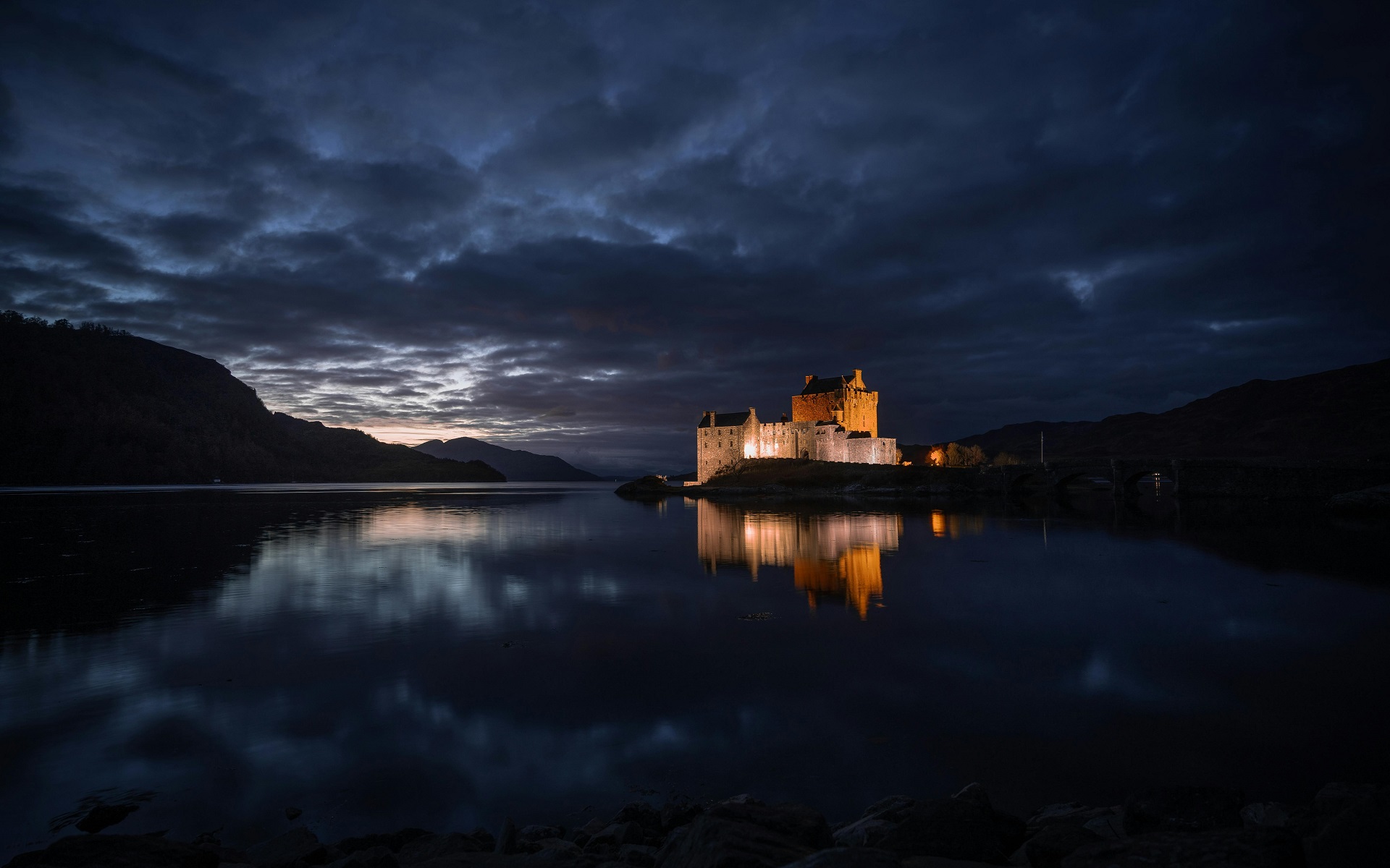 Castle illuminated at night reflected in a lake HD Wallpaper