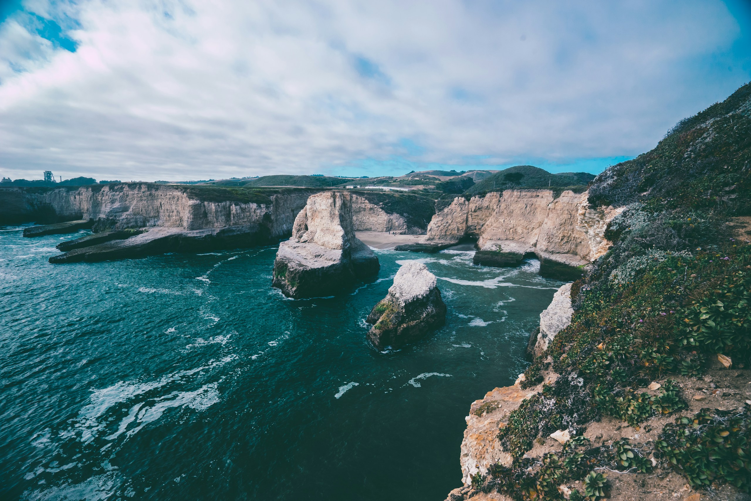 Rocky cliffs and sea stacks along the coastline HD Wallpaper