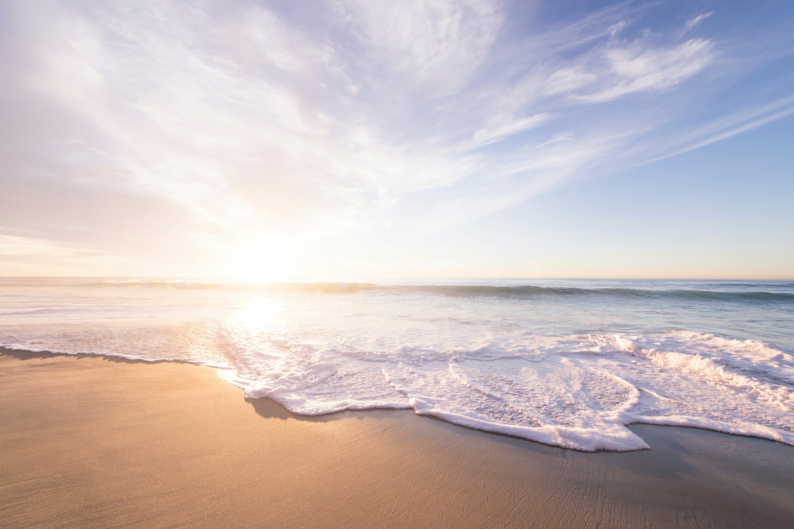 Sunrise Over a Sandy Beach with Ocean Waves HD Wallpaper