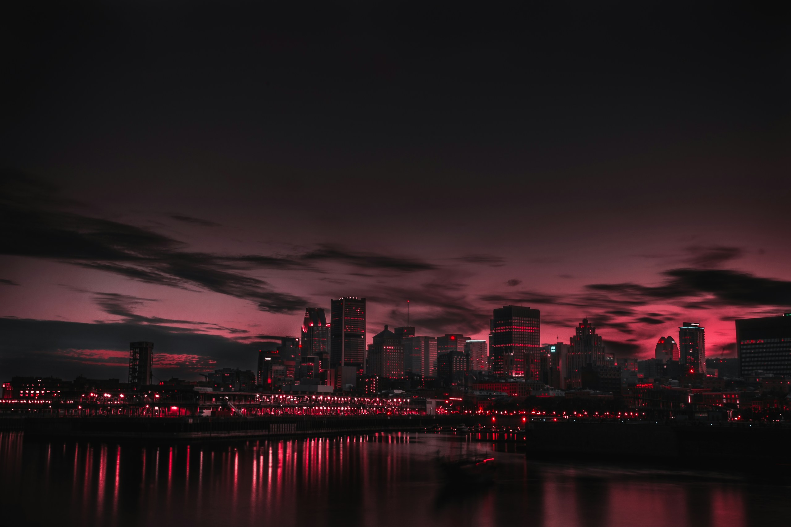 Red city skyline at night with water reflections HD Wallpaper
