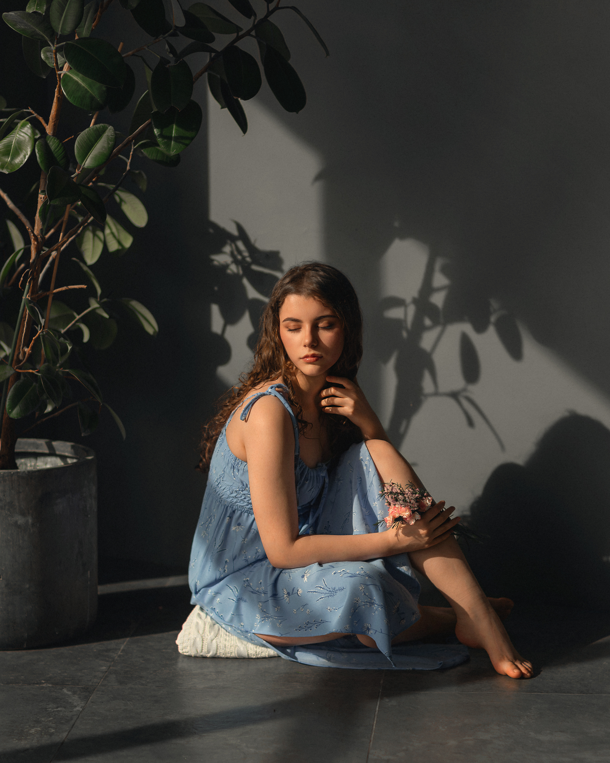 Young woman in blue dress sitting by potted plant HD Wallpaper