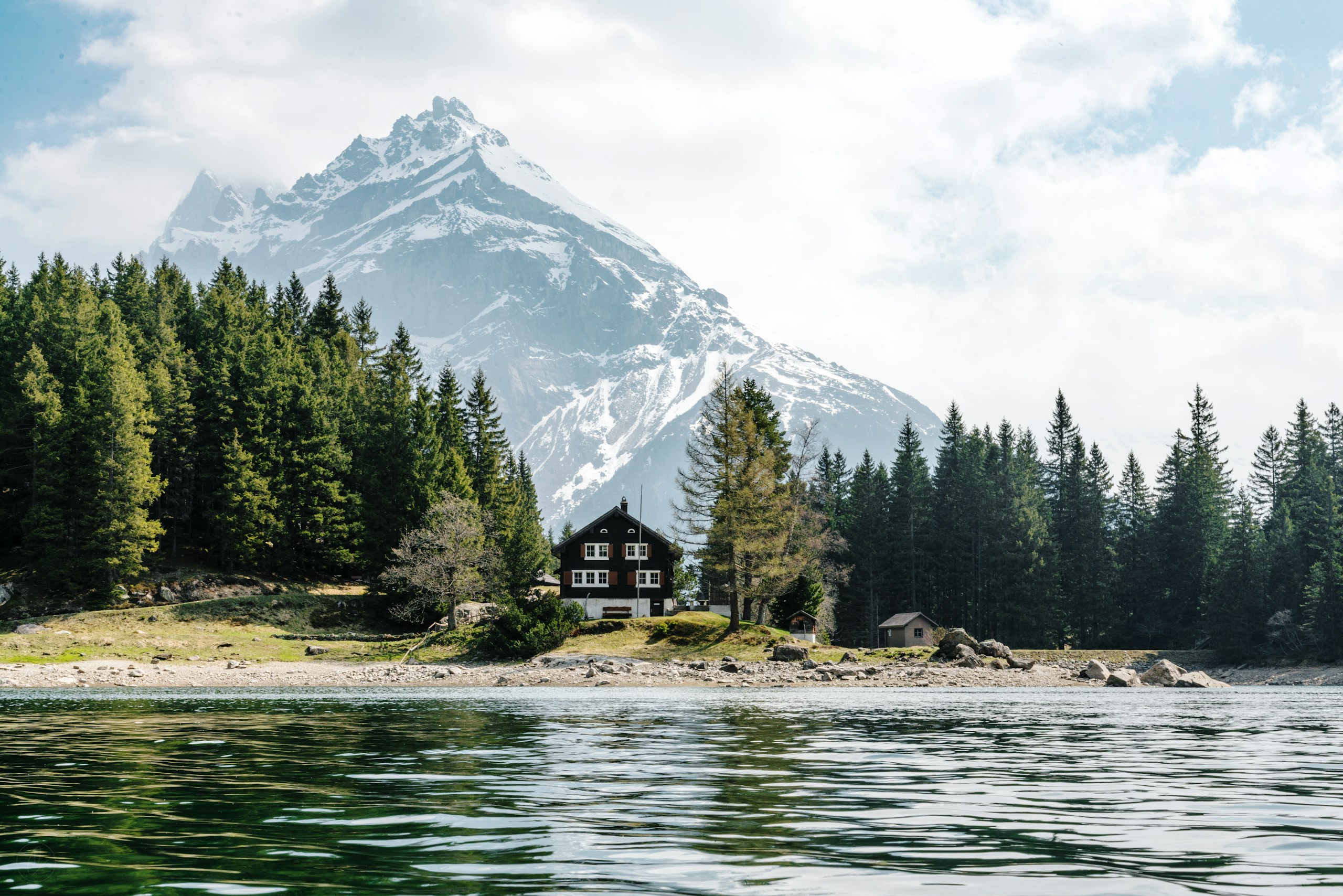 Chalet by a lake with a snow-capped mountain HD Wallpaper