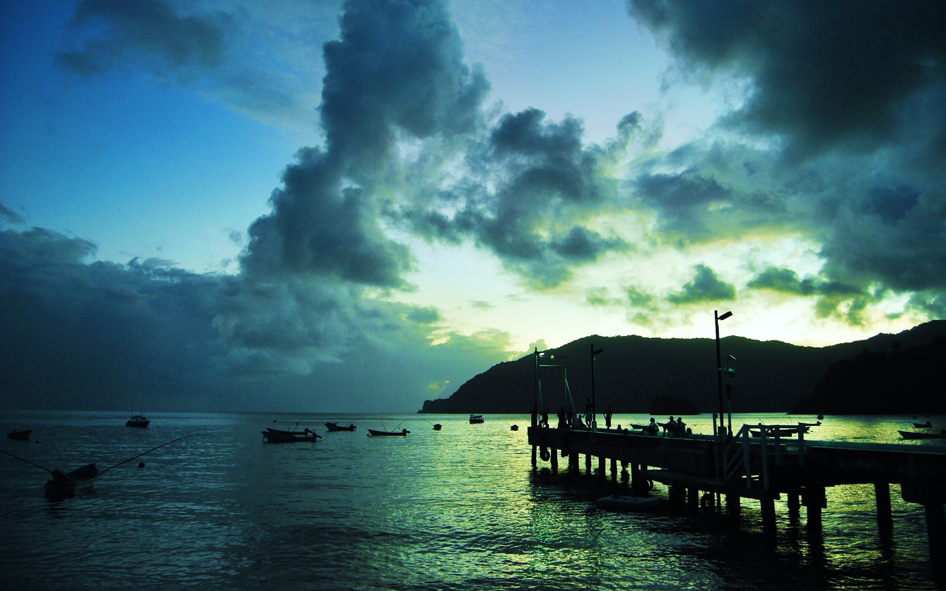 Wooden pier and boats on calm water under cloudy sky HD Wallpaper