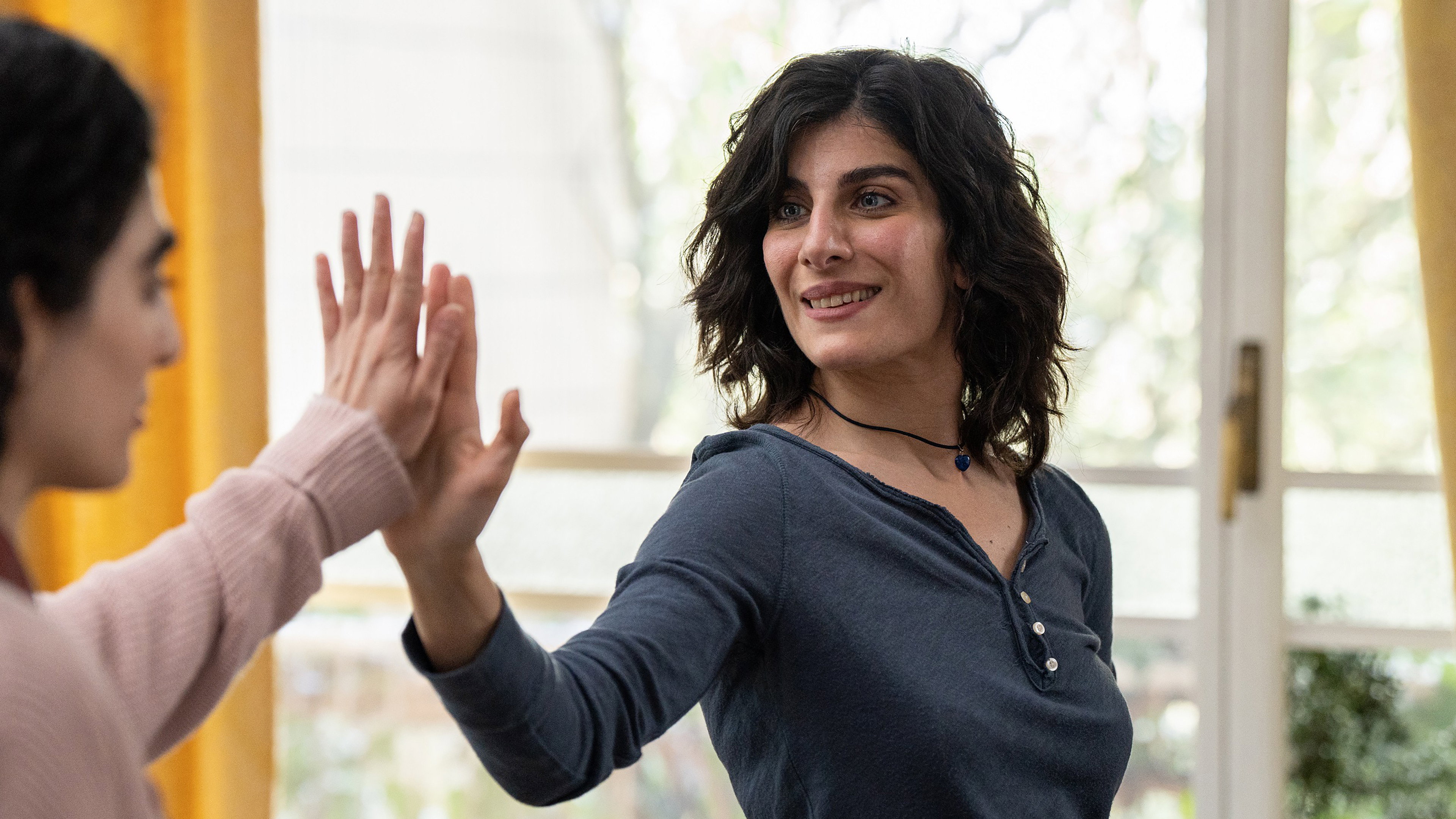 Two women high-fiving in Reading Lolita in Tehran HD Wallpaper