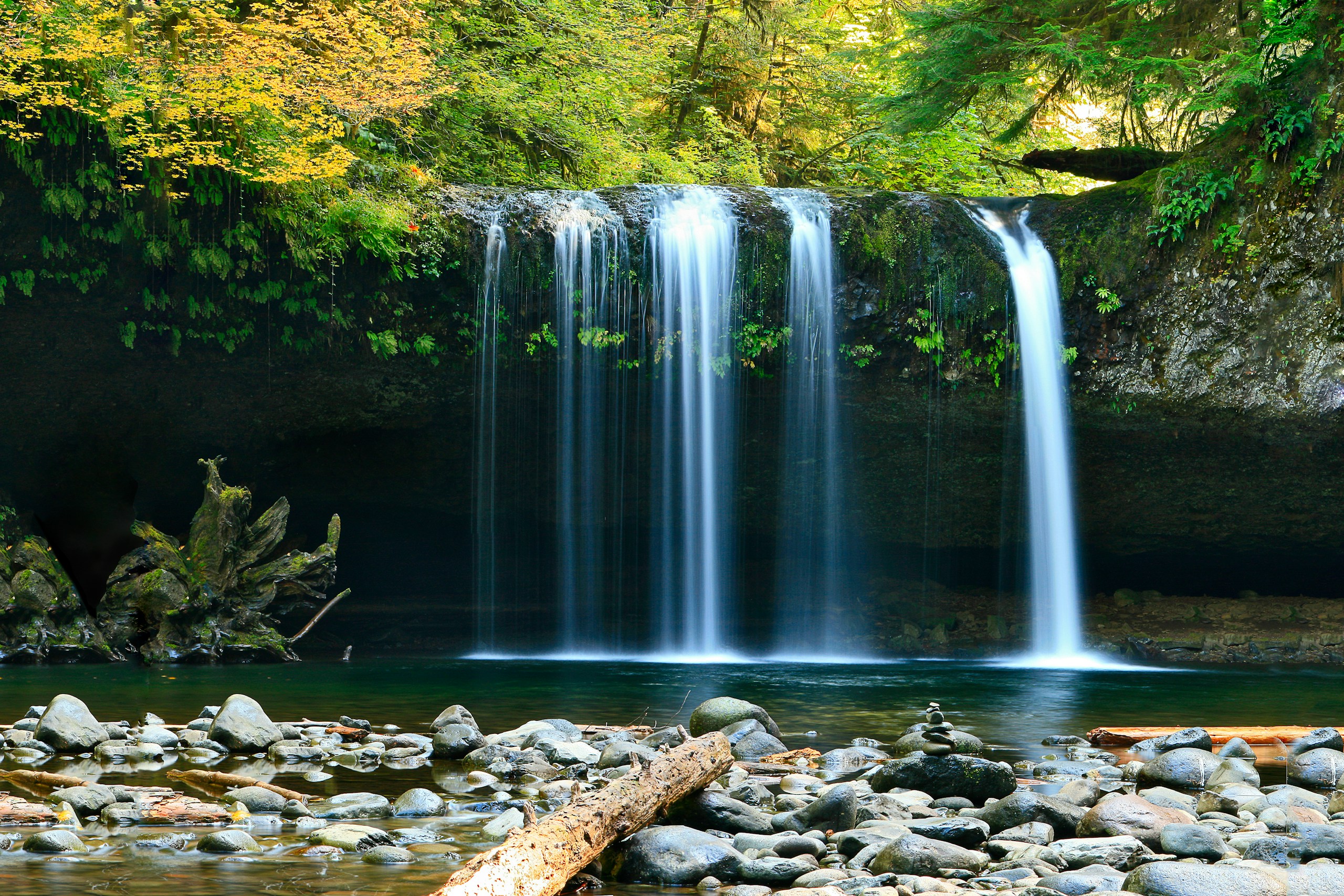 Peaceful waterfall flowing into a rocky pool HD Wallpaper