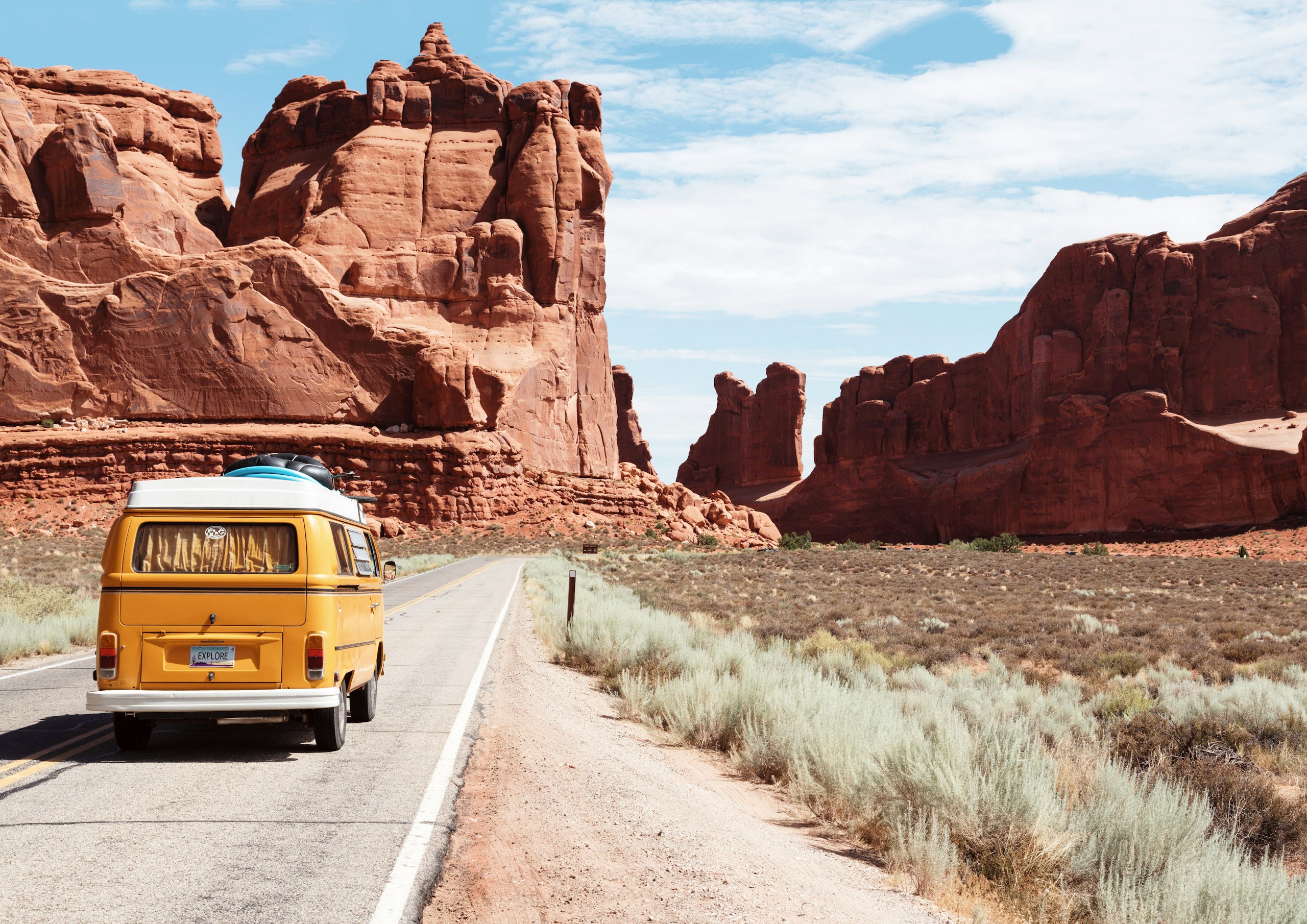 Yellow Volkswagen Van Driving on Desert Road HD Wallpaper