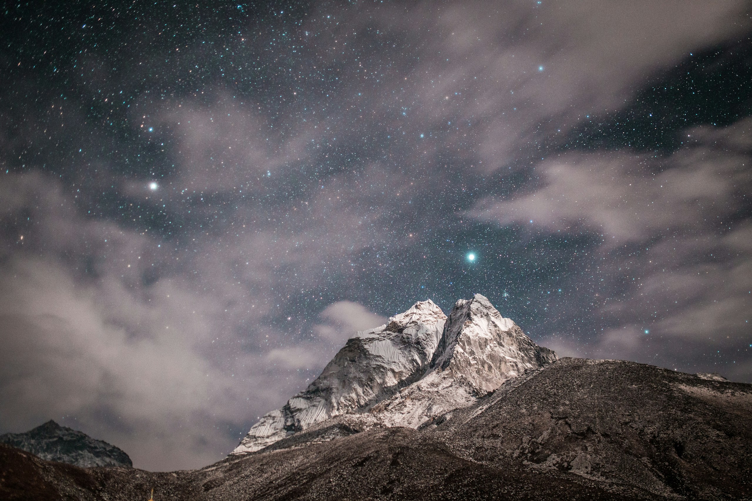 Snow-covered mountain peak under starry night sky HD Wallpaper