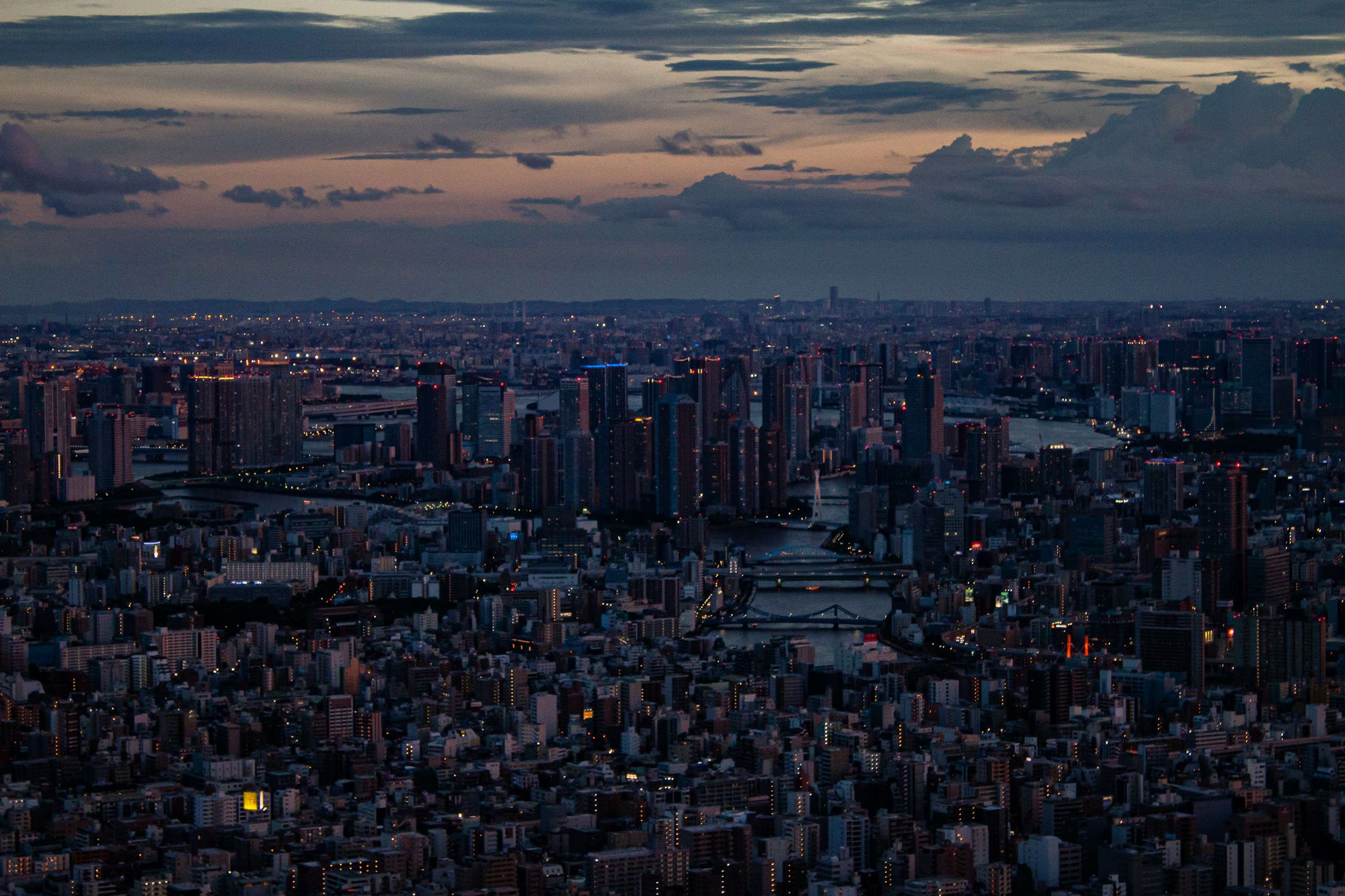 Aerial view of a dense city skyline at dusk HD Wallpaper