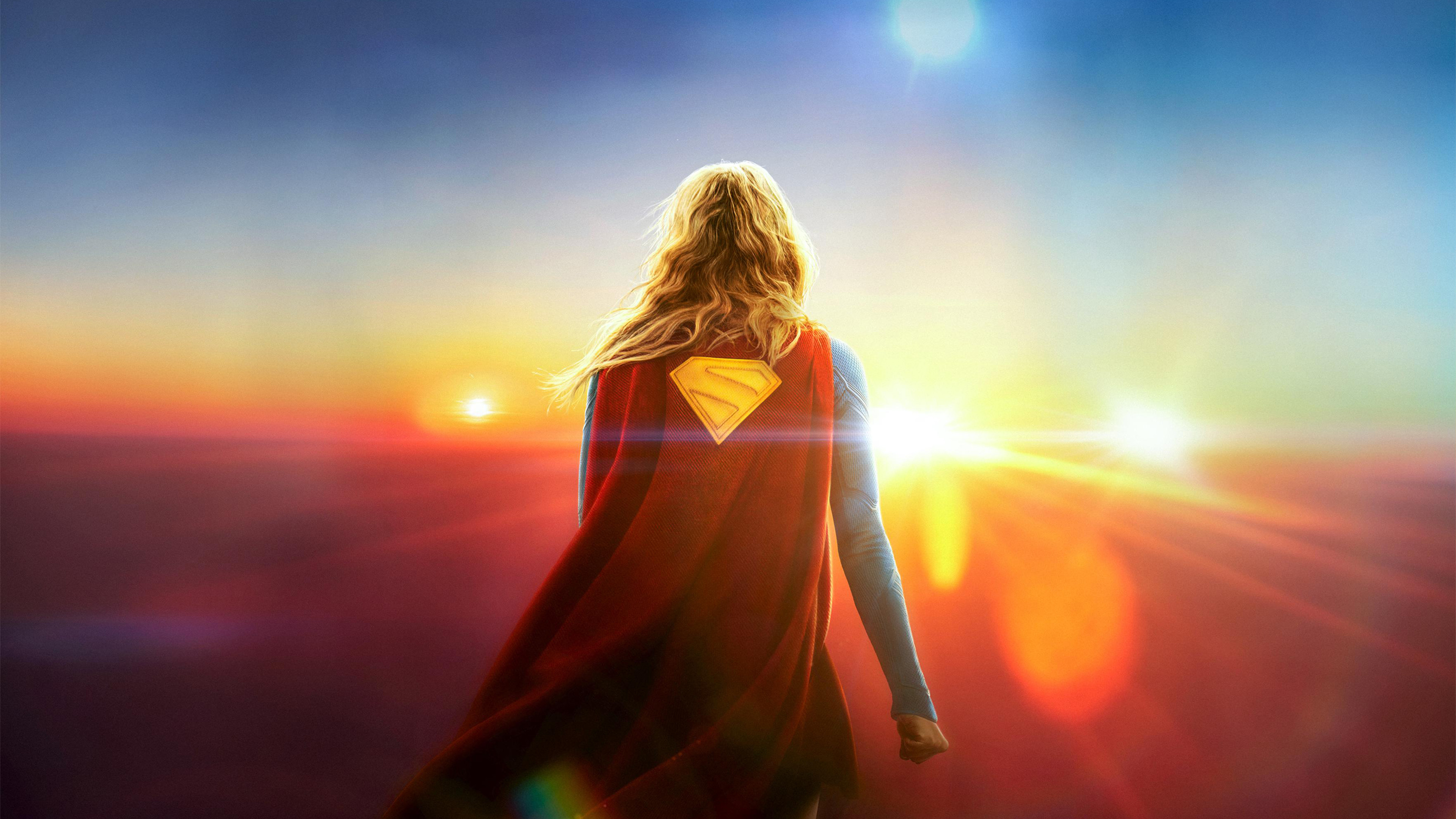 Supergirl facing a bright sunrise HD Wallpaper