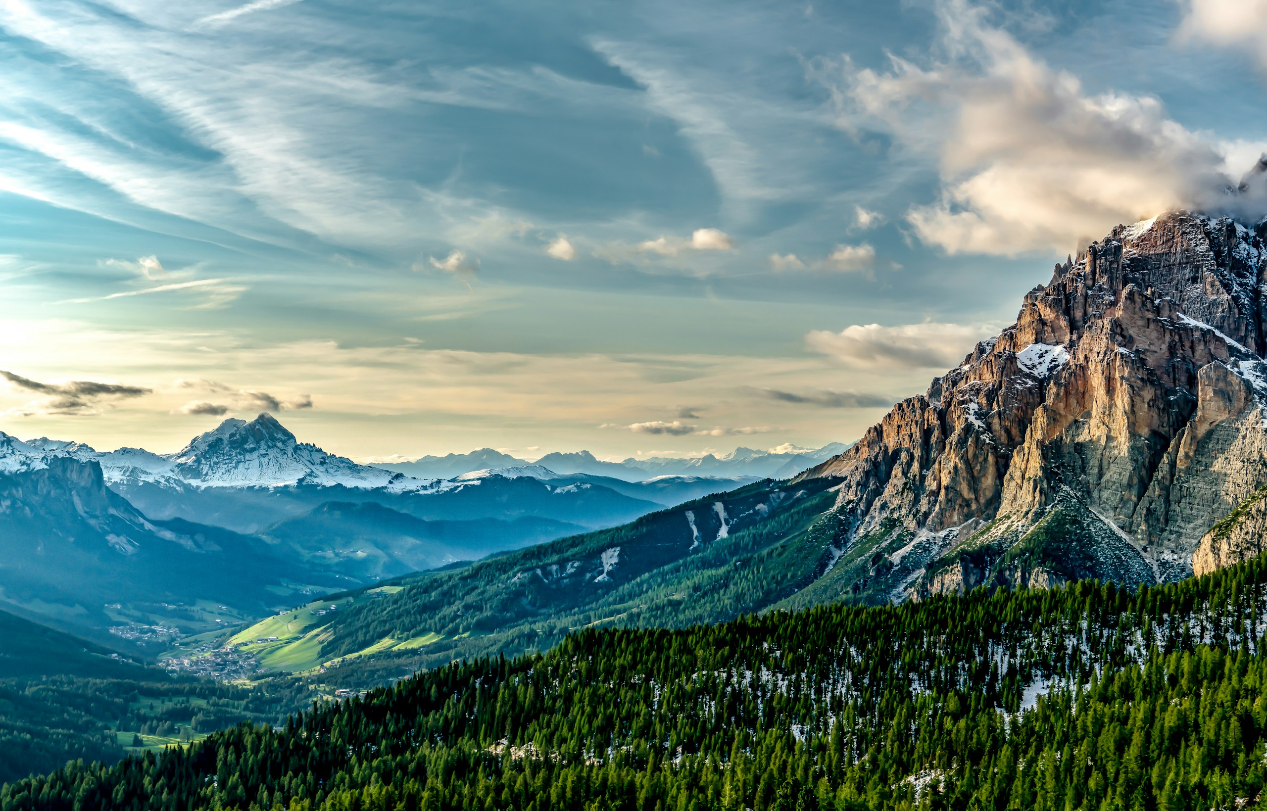 Mountain valley with pine forests and snow-capped peaks HD Wallpaper