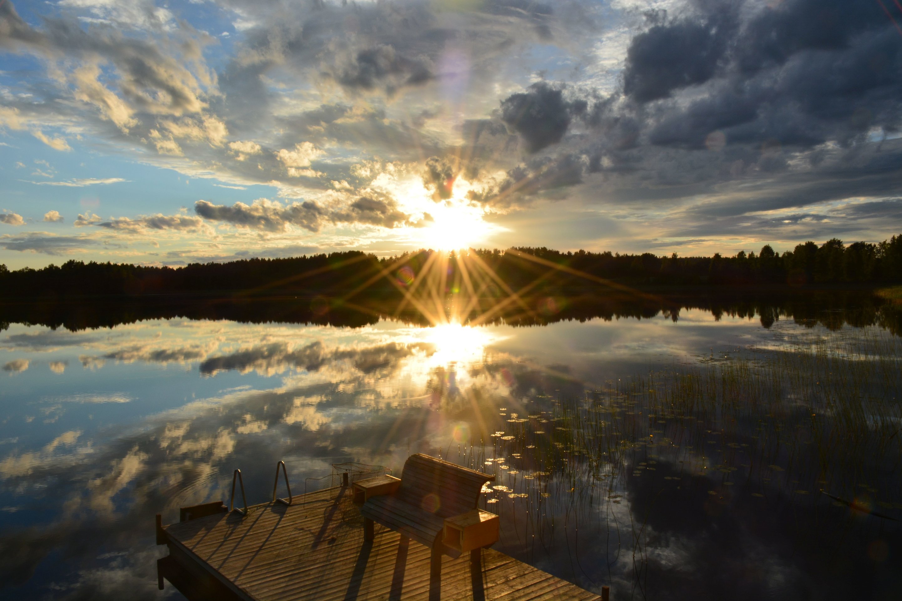 Sunset over calm lake with wooden dock and bench HD Wallpaper