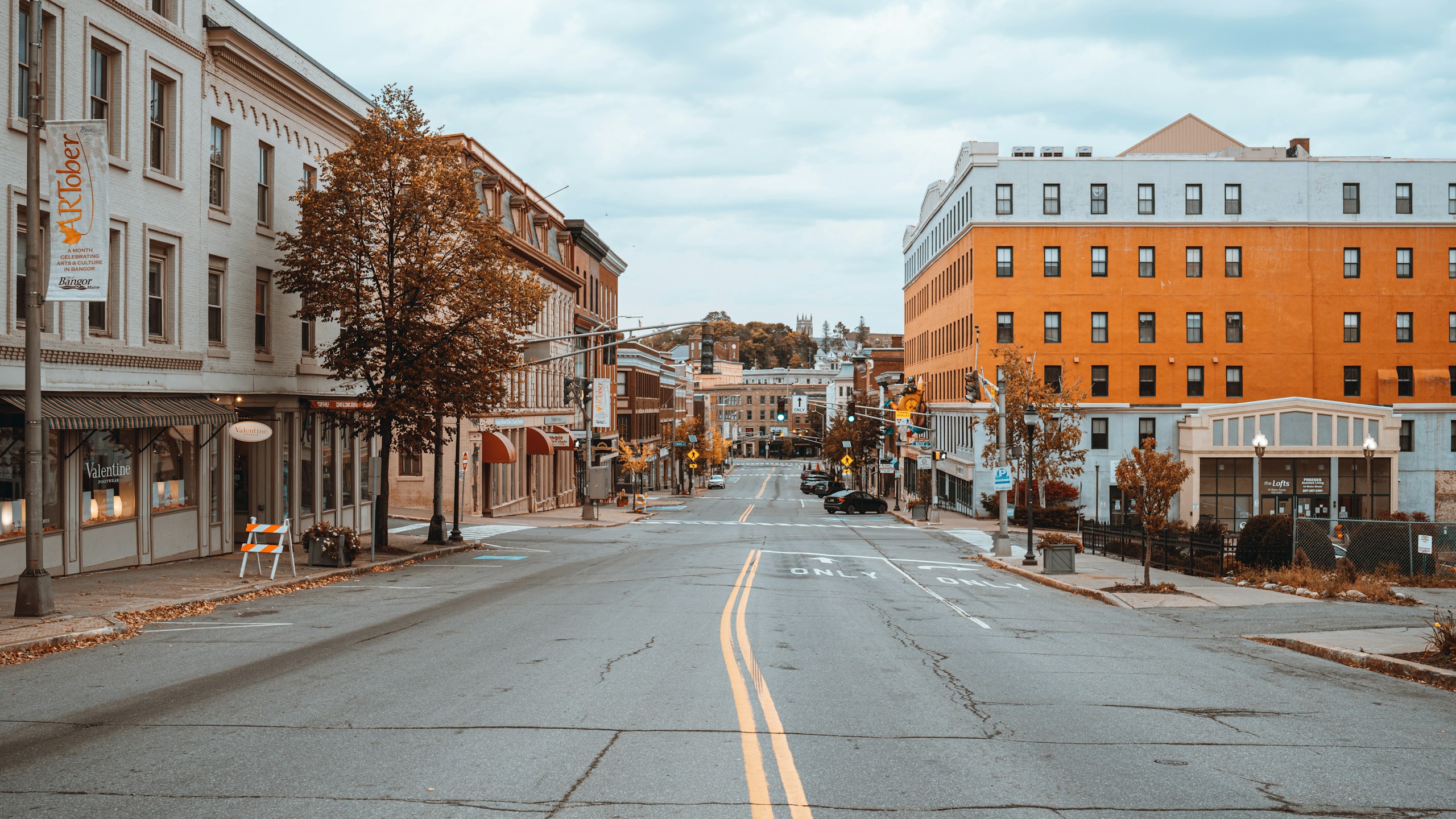 Empty asphalt street lined with buildings in Bangor HD Wallpaper