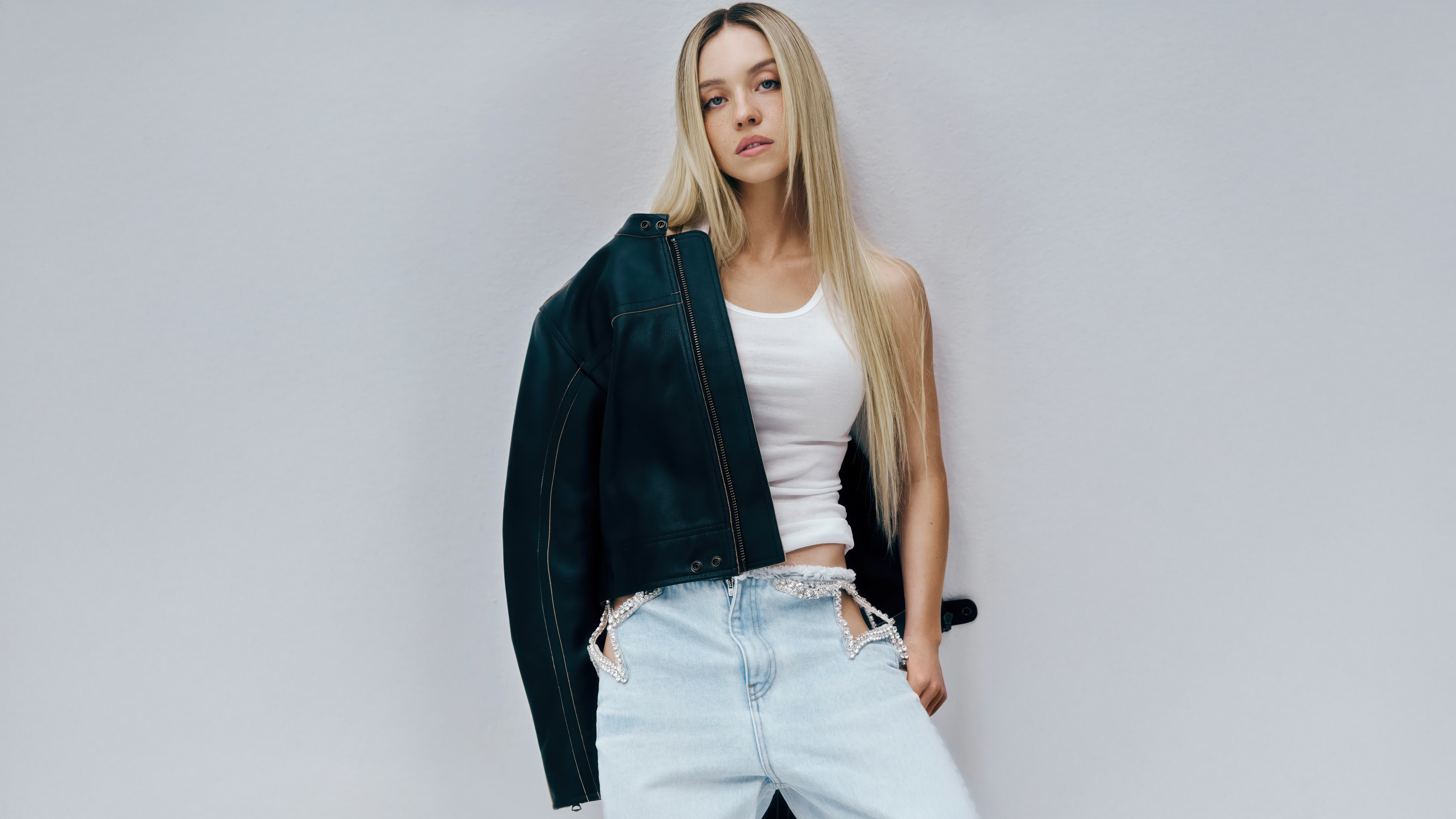 Sydney Sweeney in Leather Jacket and Cutout Jeans HD Wallpaper