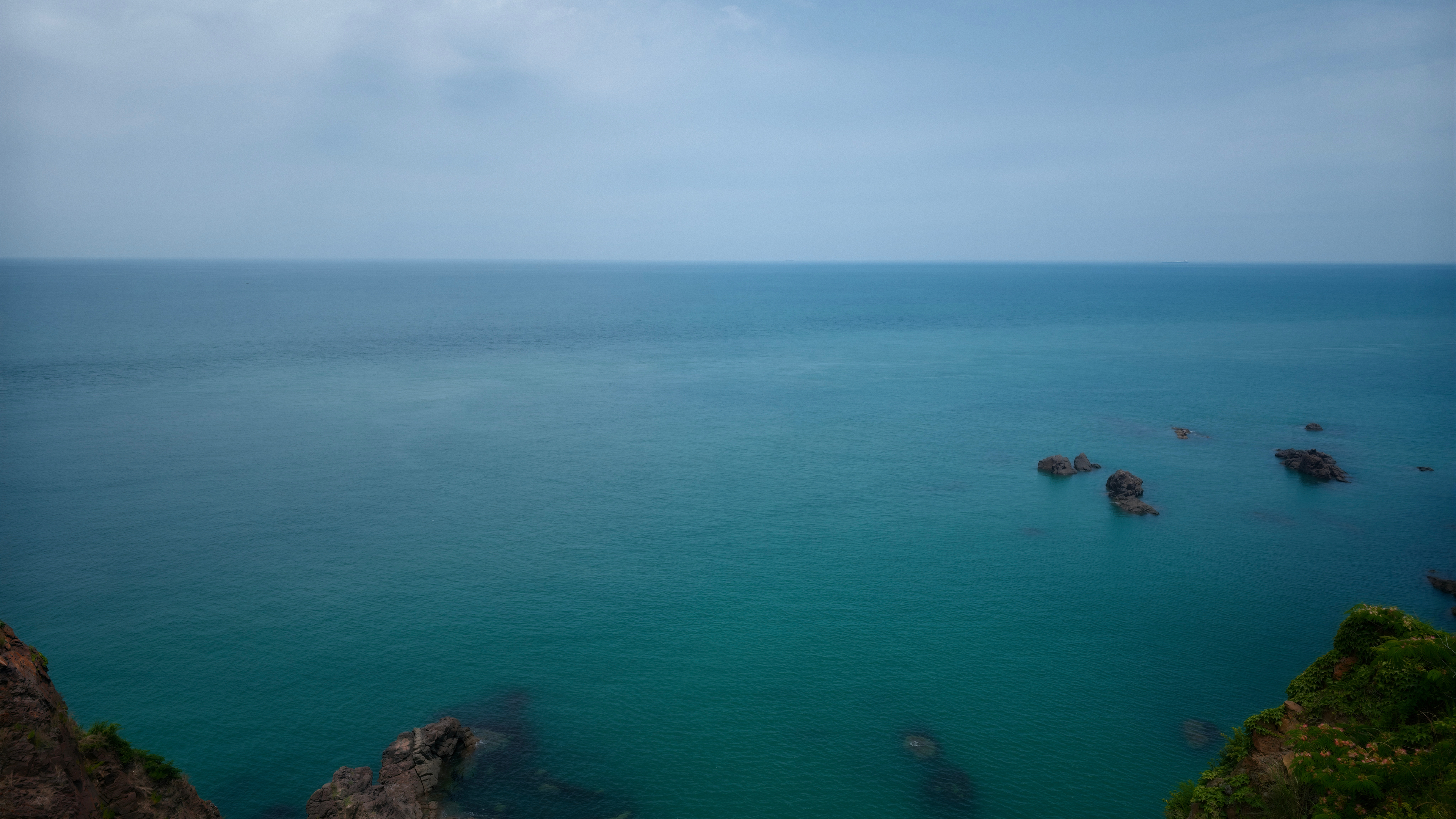 High angle view of turquoise ocean and rocky cliffs HD Wallpaper