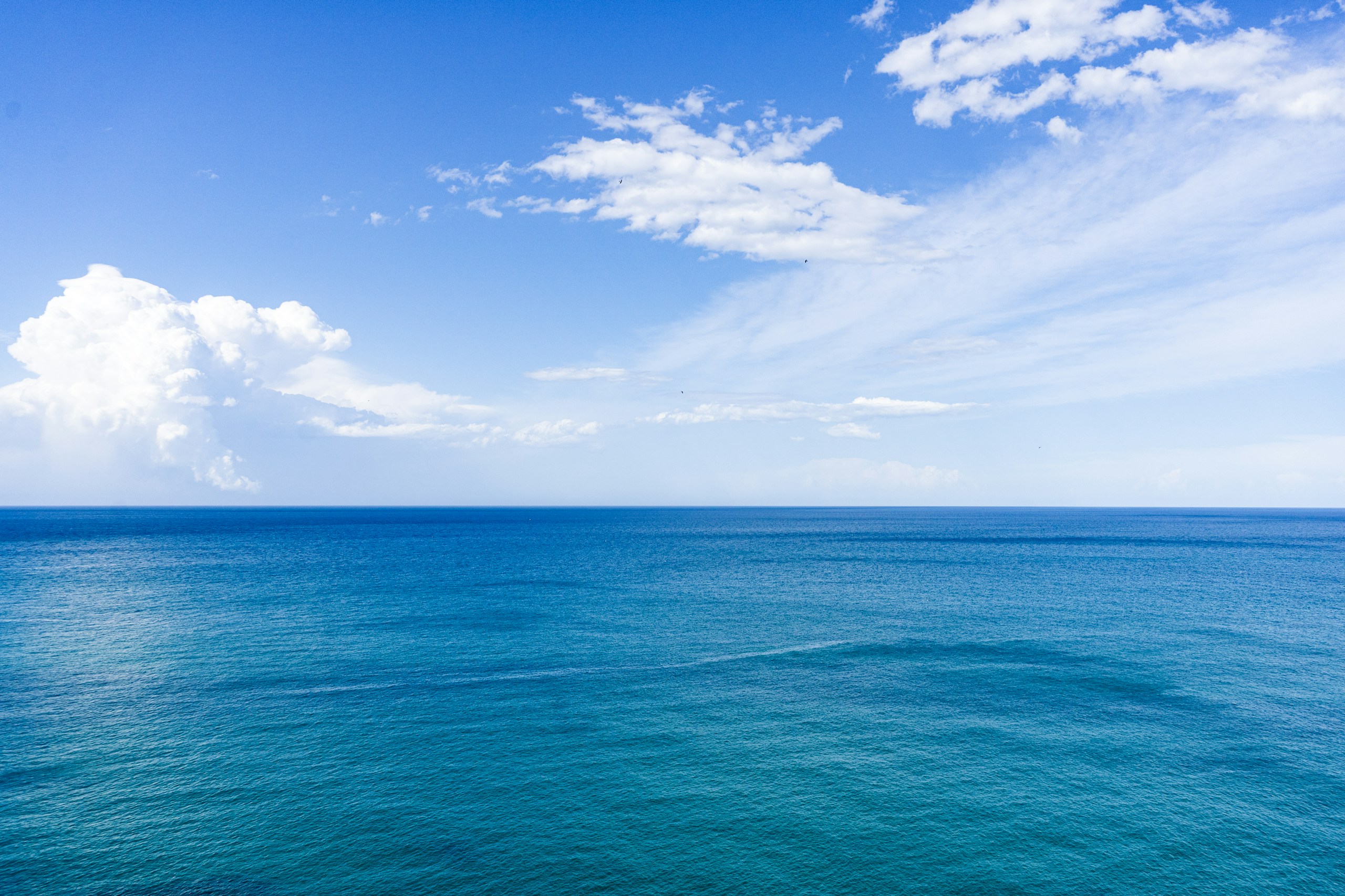 Blue sea under blue sky with white clouds HD Wallpaper