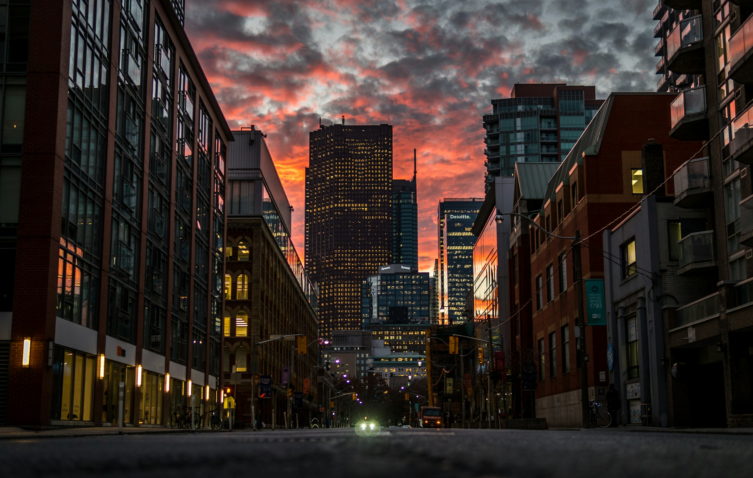 City street view of skyscrapers under a sunset sky HD Wallpaper