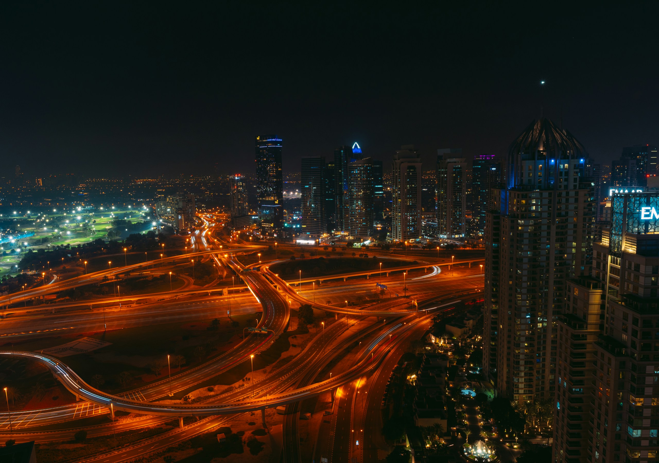 Night view of city skyline and highway interchange HD Wallpaper